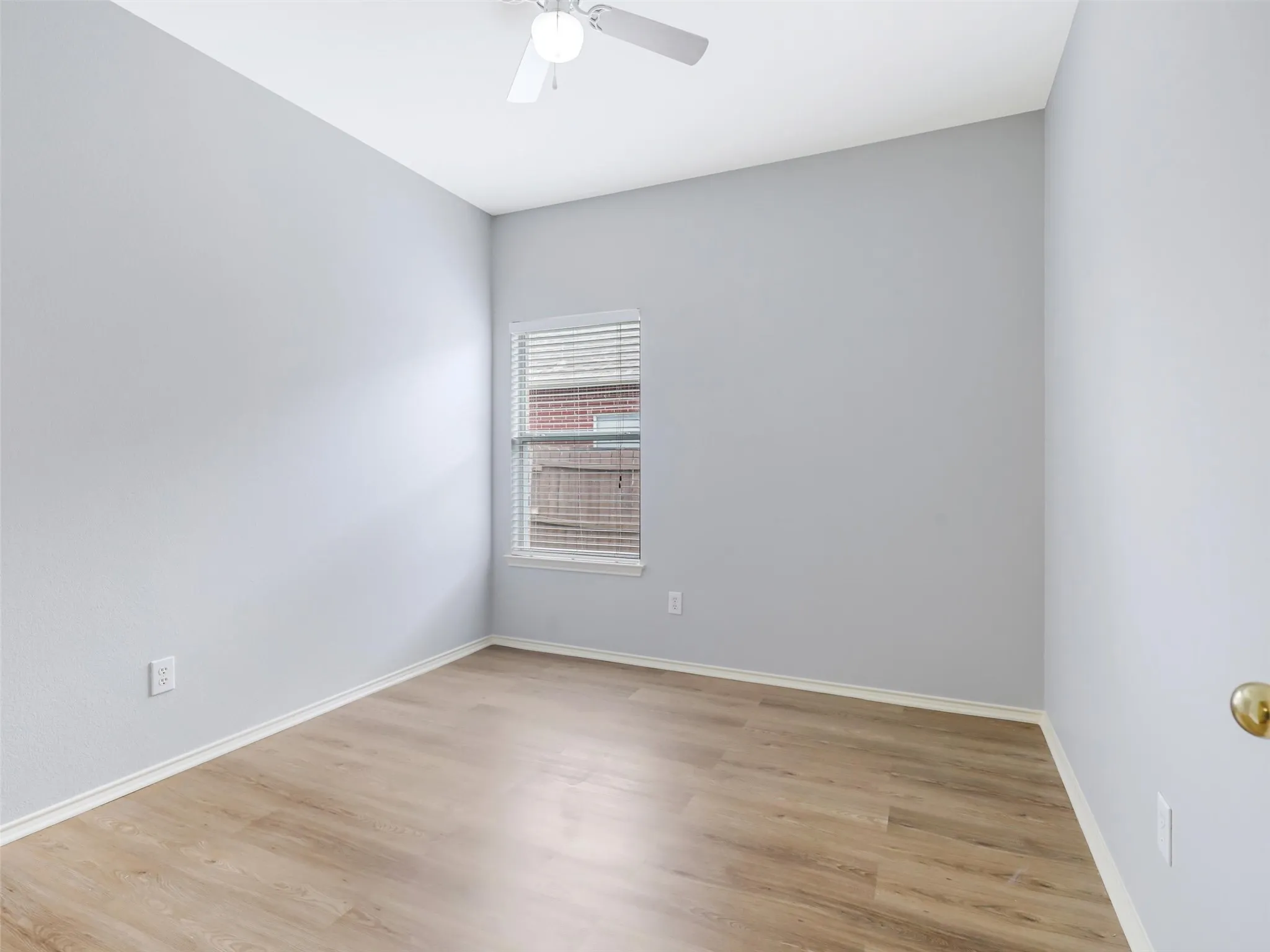 Wood-finish flooring, neutral wall tones, and ceiling fan with integrated lighting