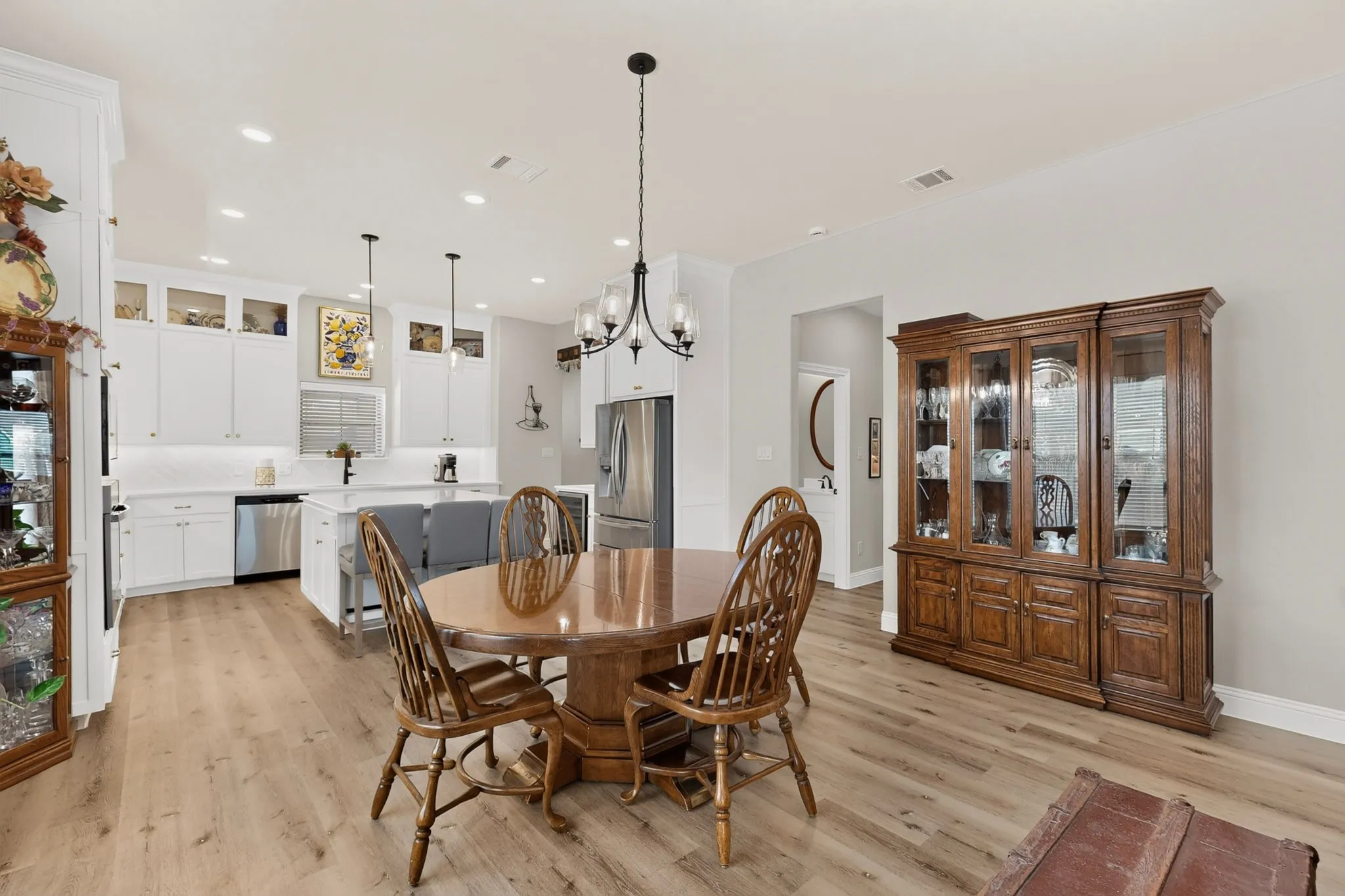 Open-concept living area featuring wood-finish flooring, recessed lighting, and a chandelier