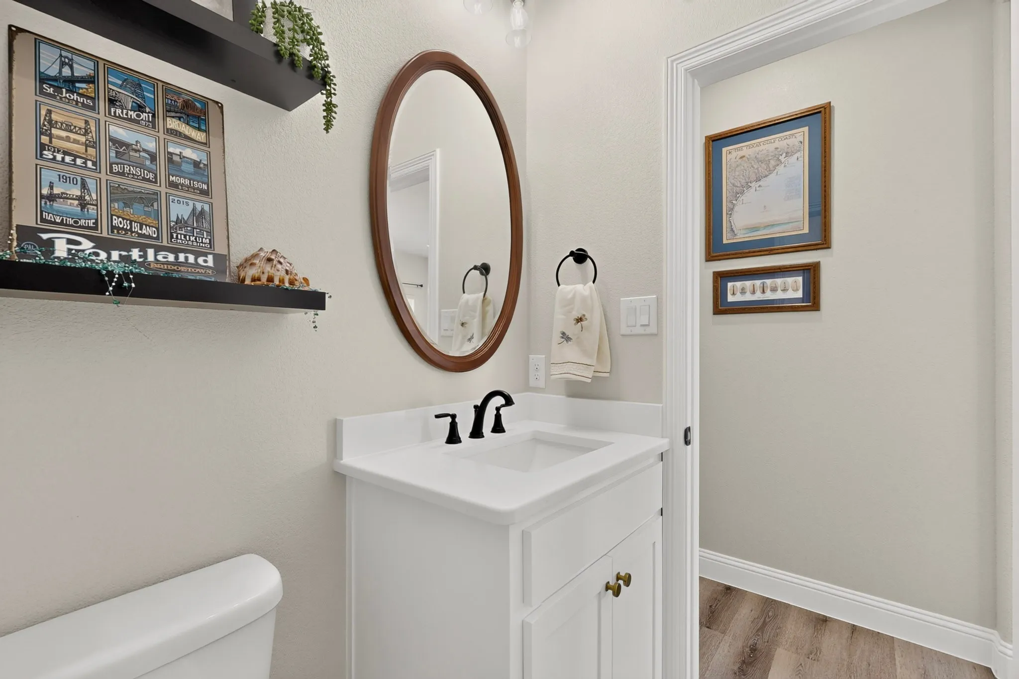 Half bath, White vanity with a single basin sink, matte black faucet, and brass hardware