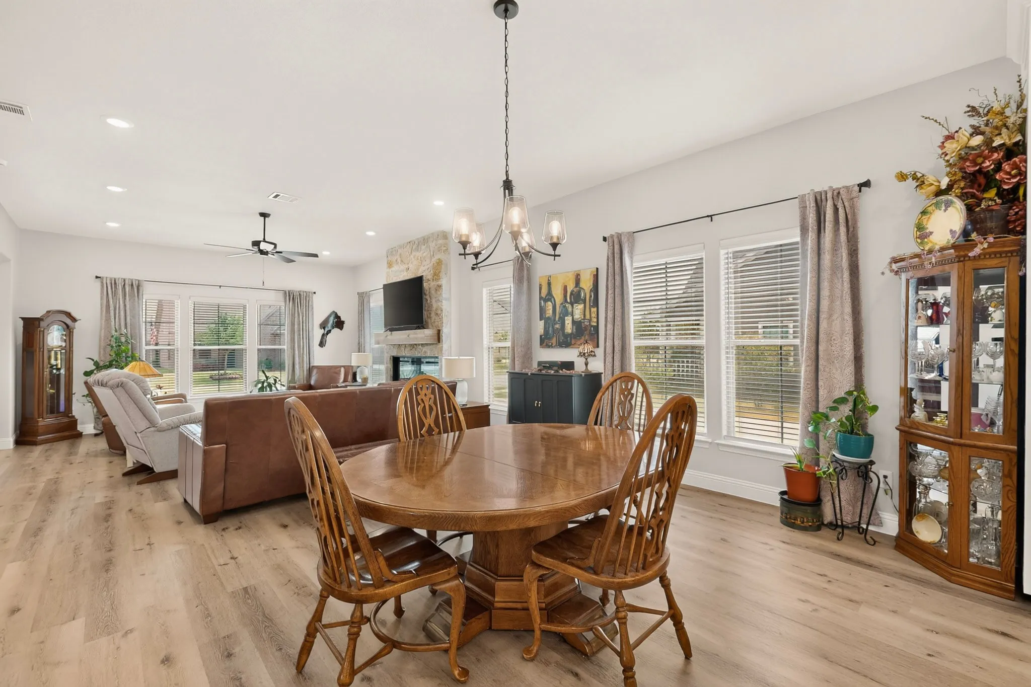 Open-concept living area featuring wood-finish flooring, recessed lighting, and a chandelier with glass shades