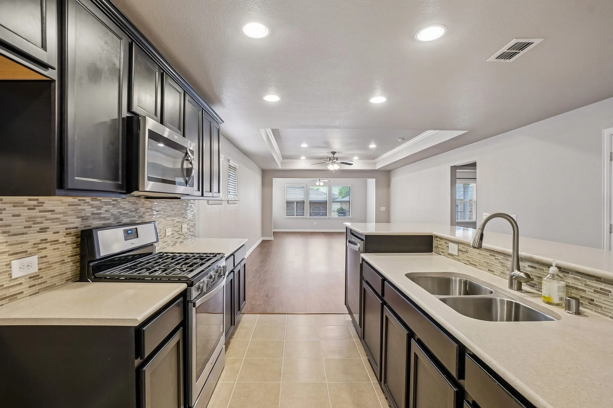 Kitchen featuring stainless steel appliances, dark wood cabinetry, and a tile backsplash