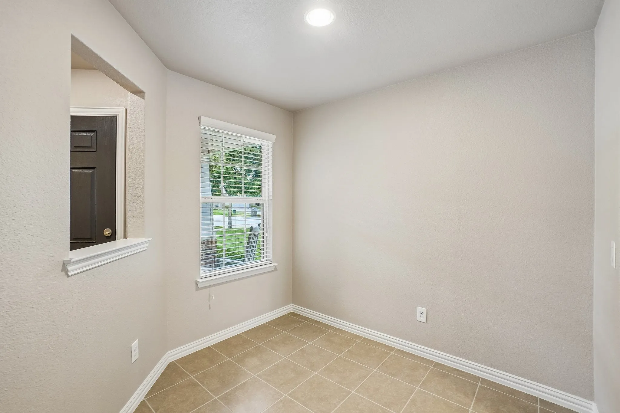 Recessed lighting, neutral wall tones, tile flooring, window with white blinds, and white trim molding