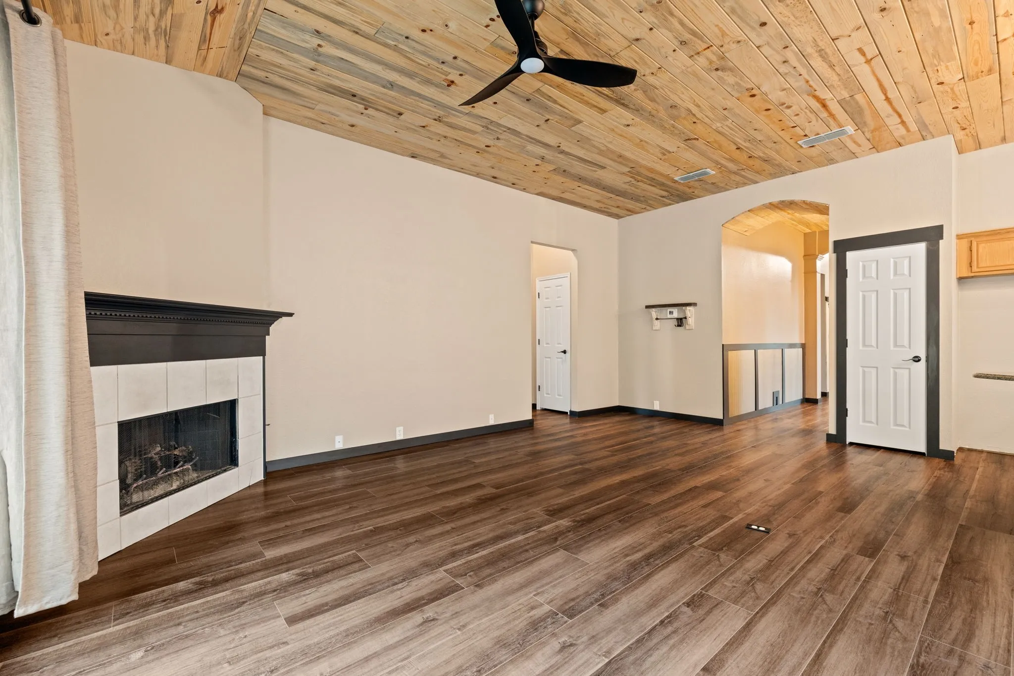 Angled fireplace with white tile surround and dark wood mantel