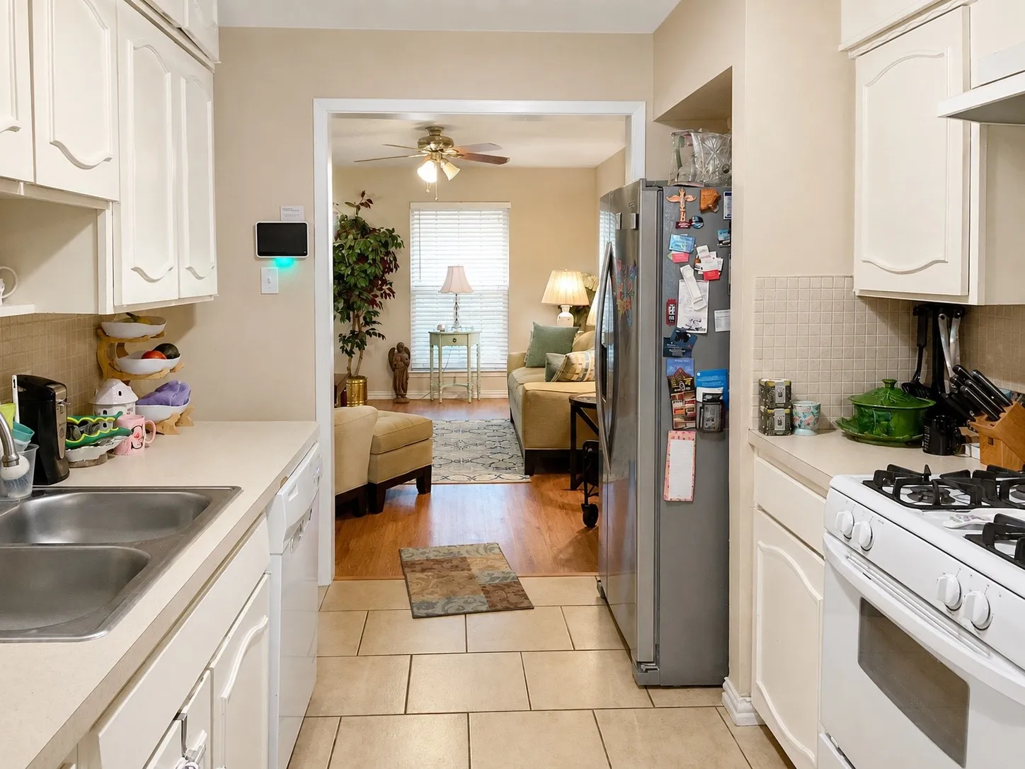 Kitchen featuring a double basin sink, white cabinetry, a built-in oven range, and tiled flooring