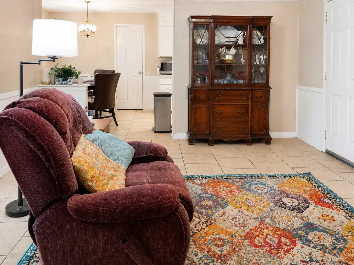 Tile flooring, wainscoting, built-in cabinetry, overhead lighting, interior door