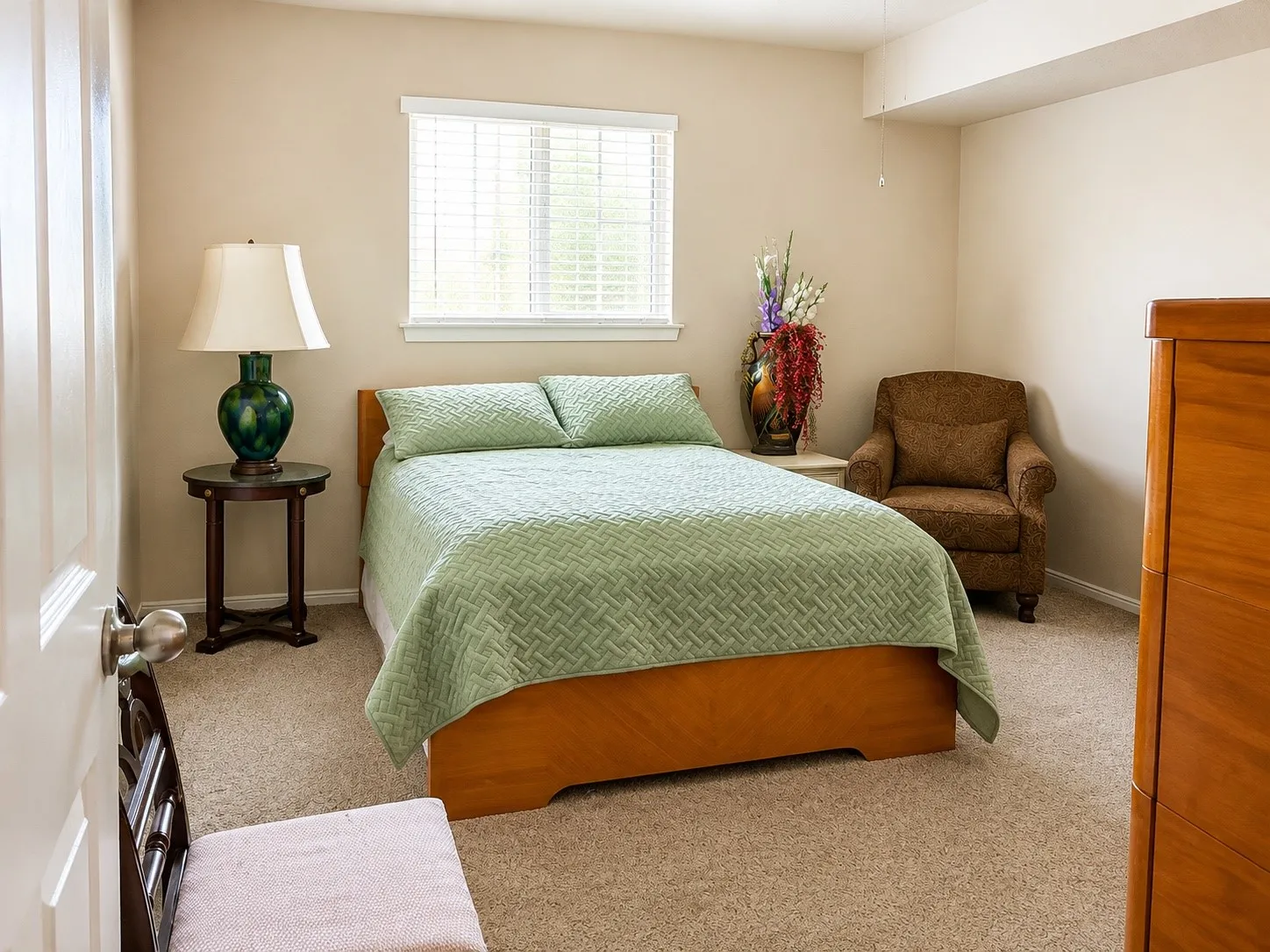 Neutral tone walls, window with blinds, and carpeting throughout