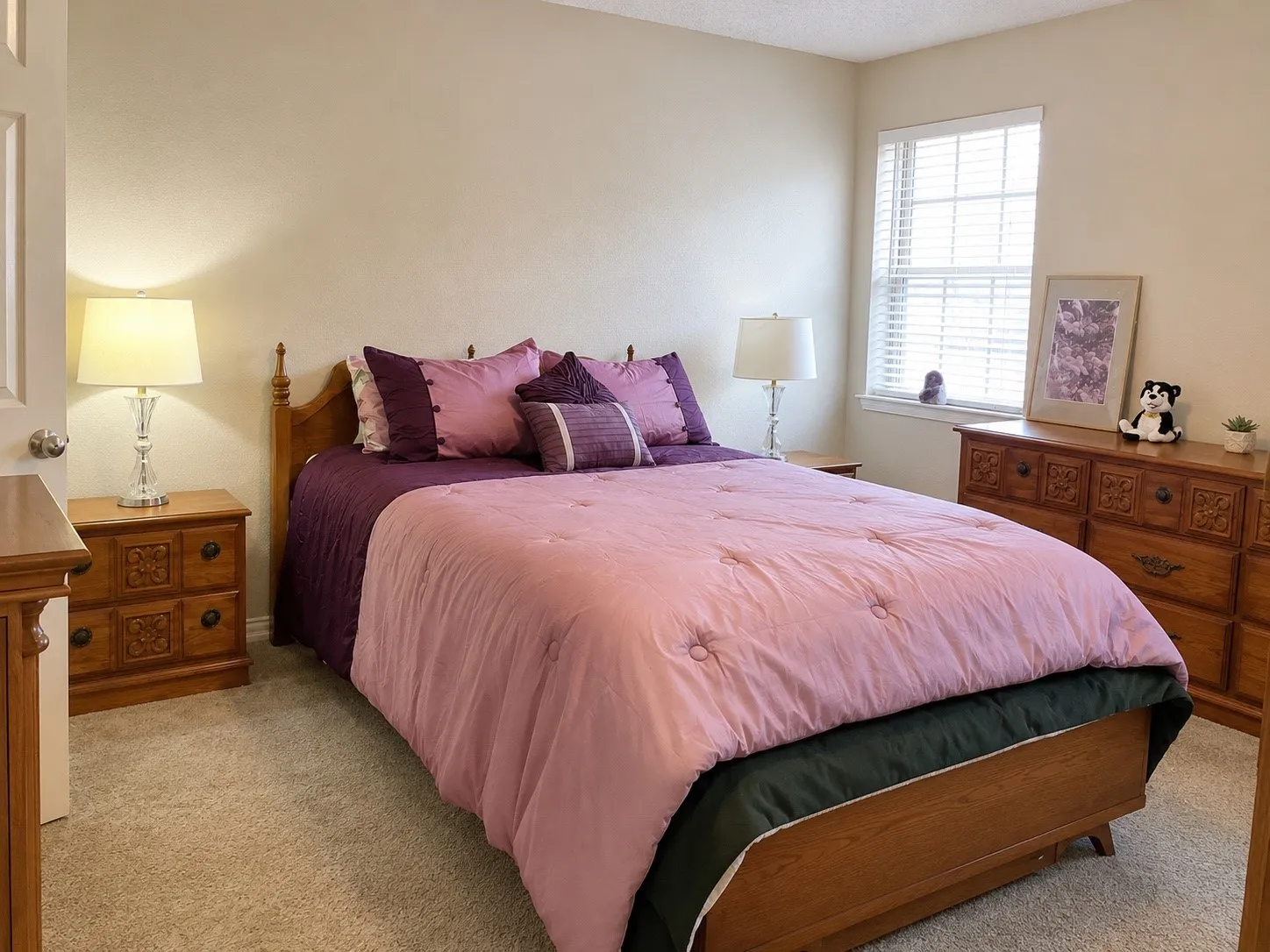 Window with blinds, wall-to-wall carpeting, light-toned walls, and a white interior door