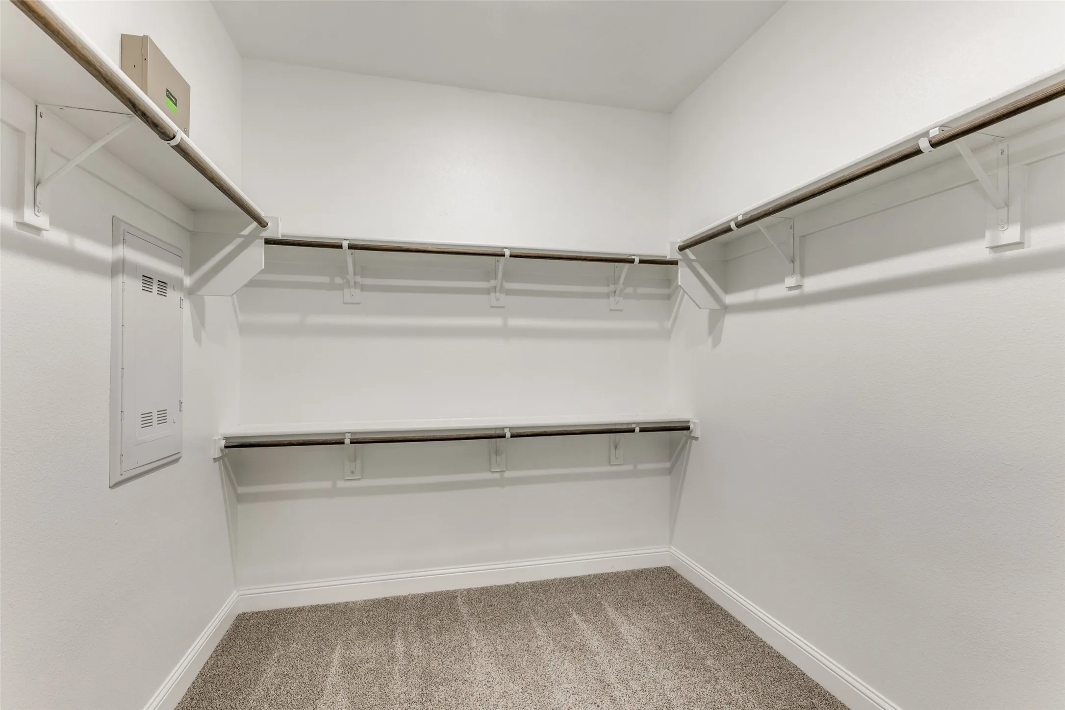 Spacious closet with light carpet and electric panel