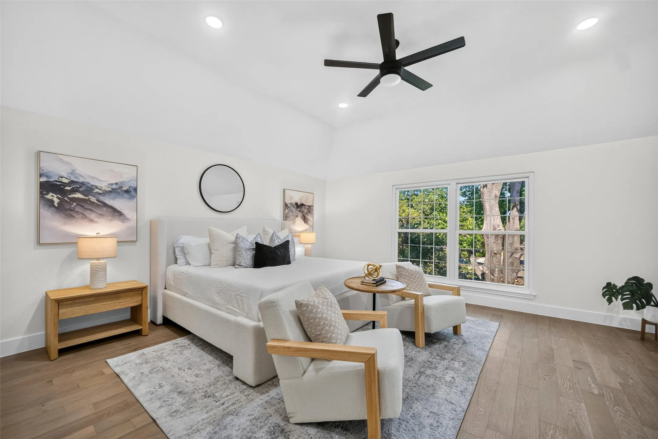 Vaulted ceiling, recessed lighting, wood-finish flooring, ceiling fan, and large window