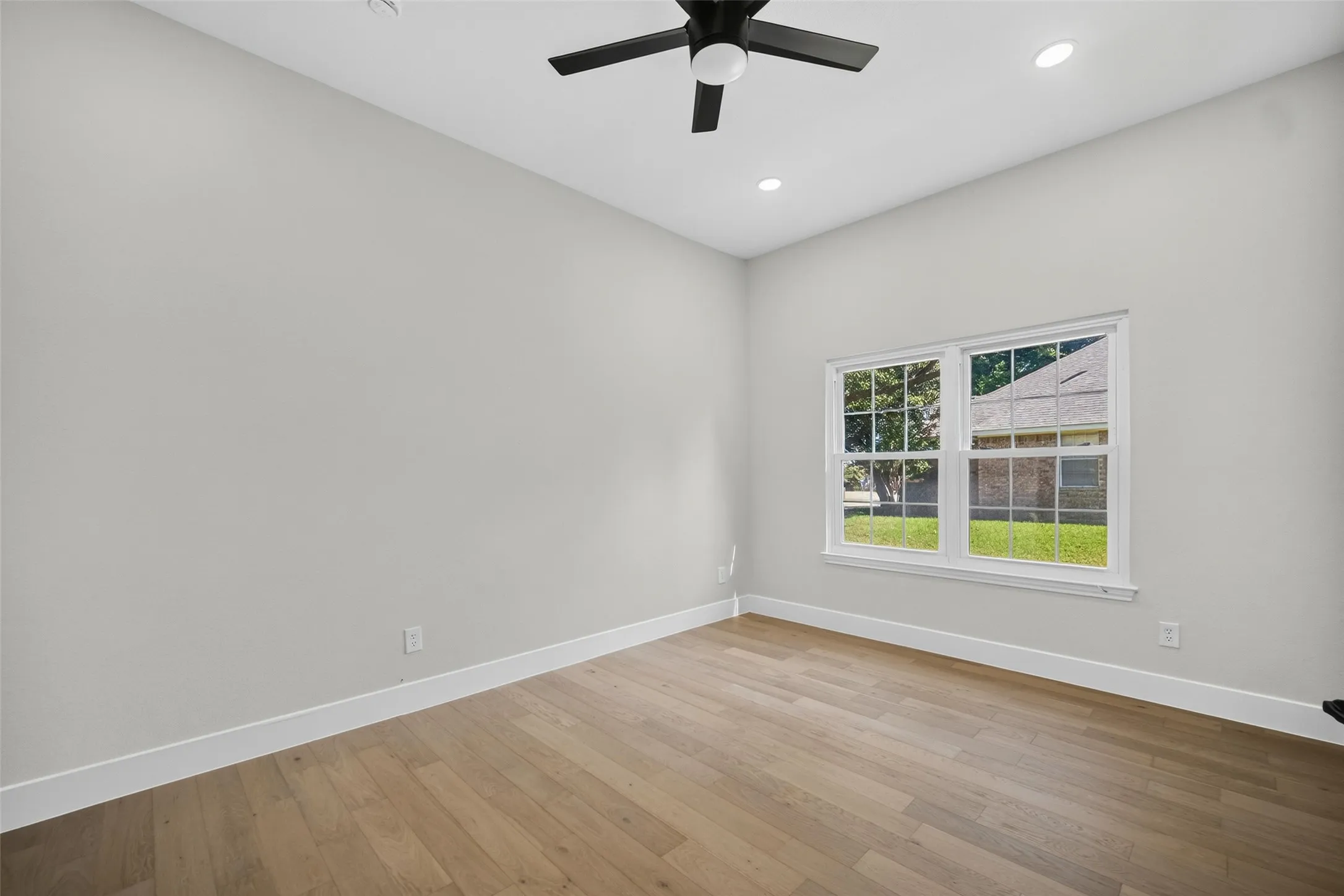 Wood-finish flooring with white trim, a double window, recessed lighting, and a ceiling fan