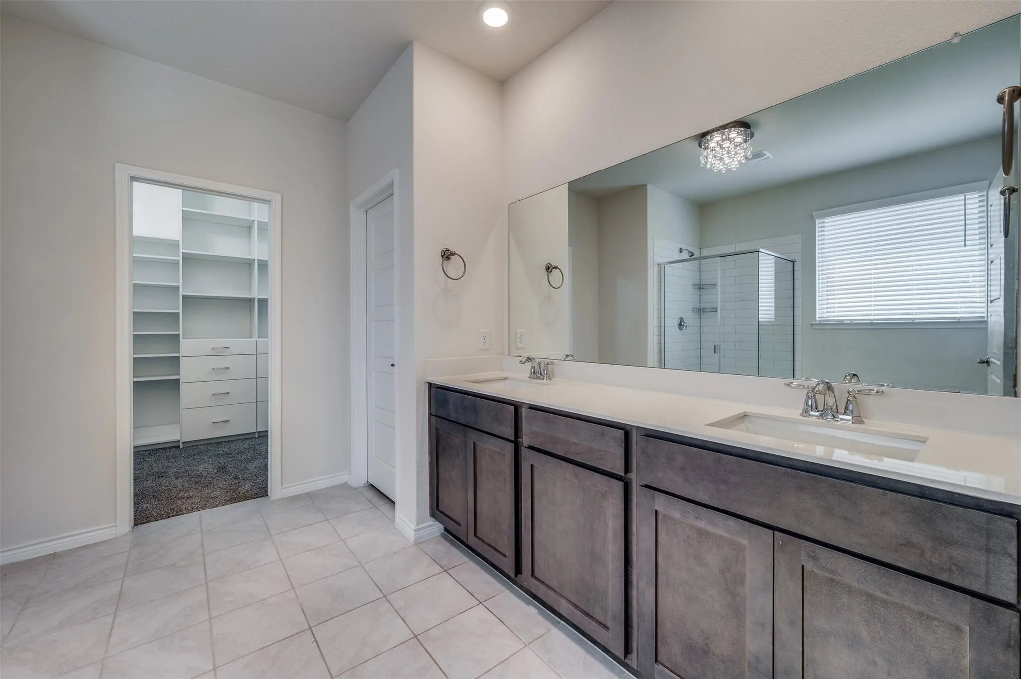 Dual vanity with quartz countertops, undermount sinks, and dark wood-finish cabinetry