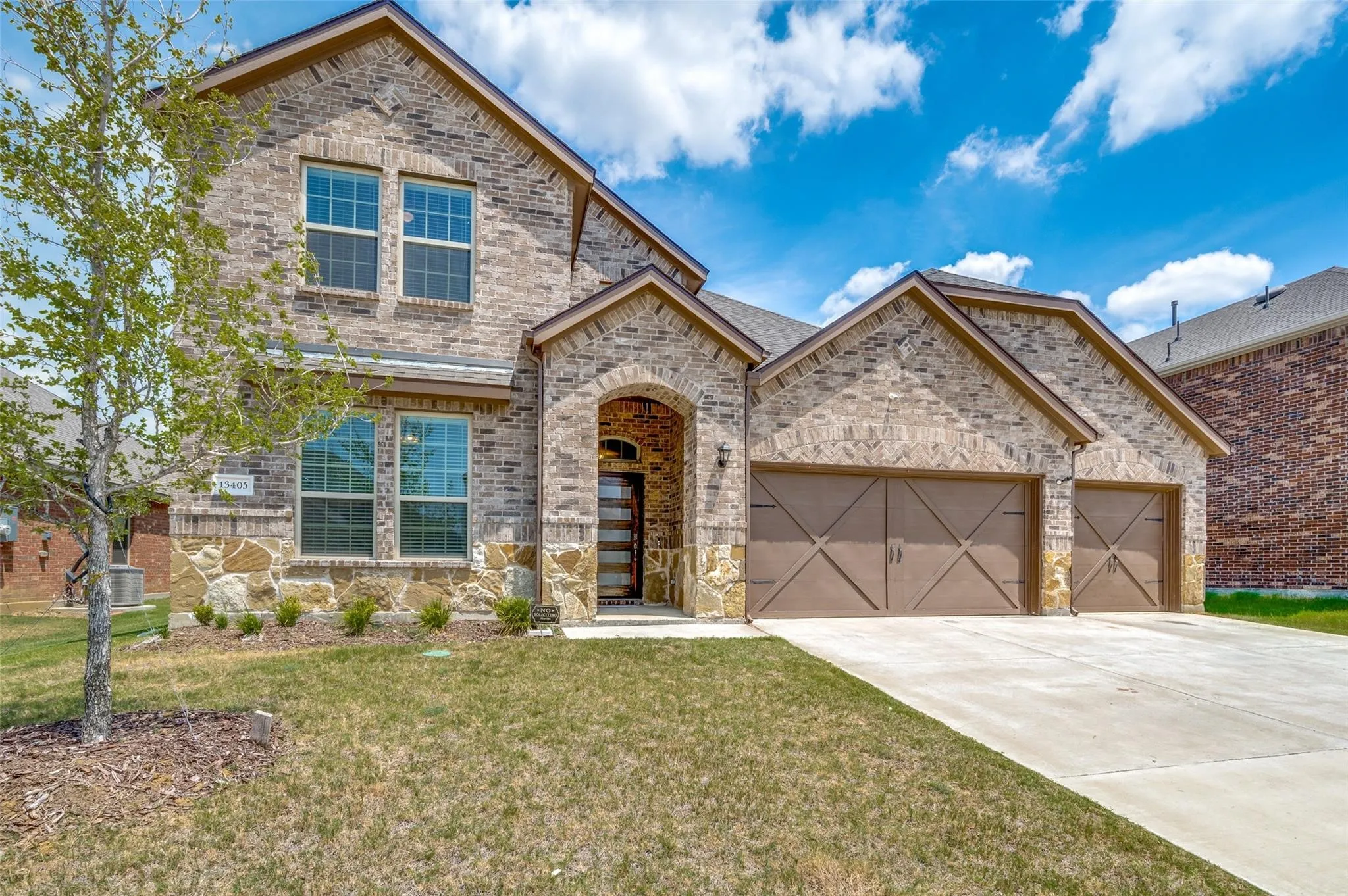 Brick exterior with stone accents and a covered entry
