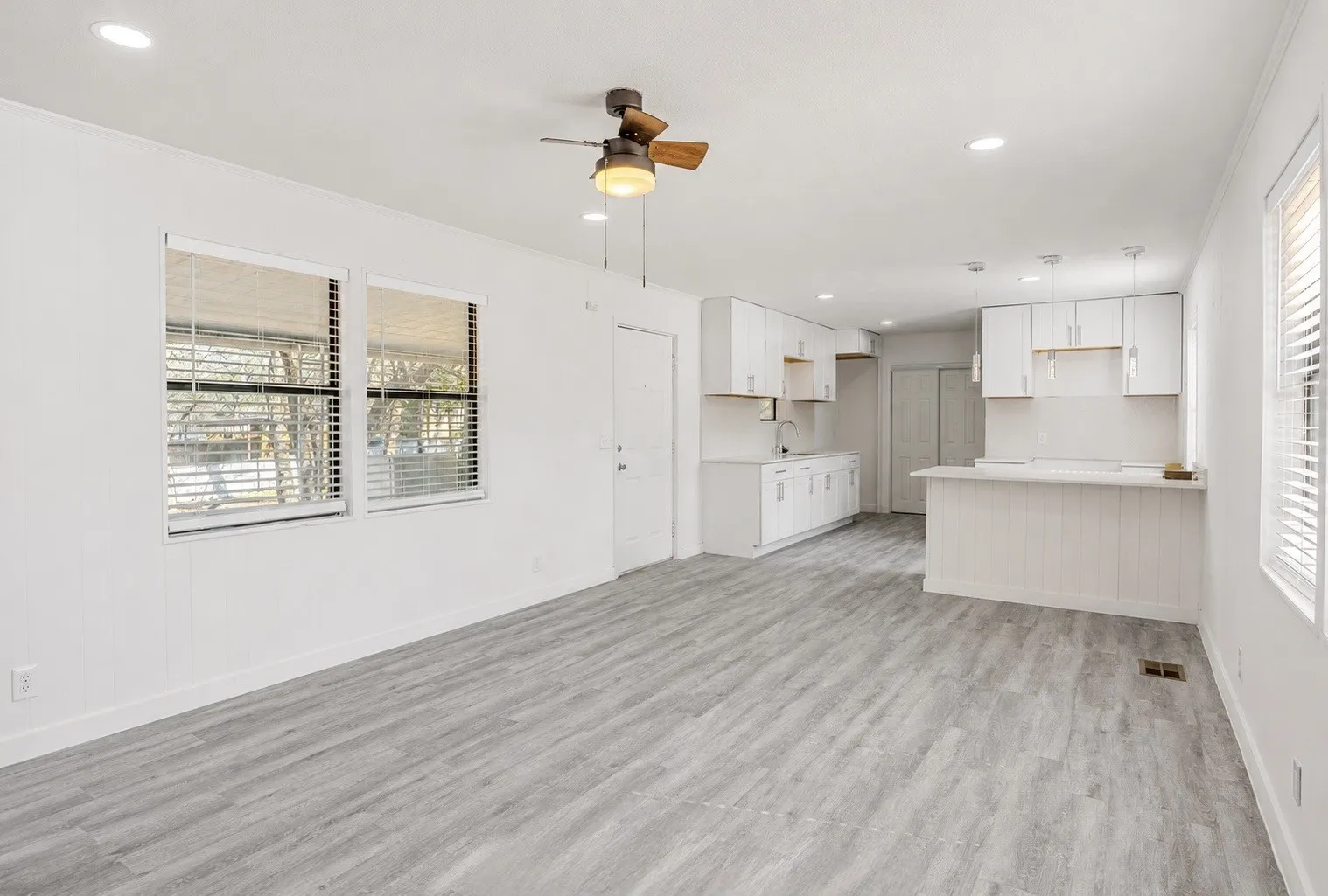 Light gray wood-finish flooring, white walls, and recessed lighting