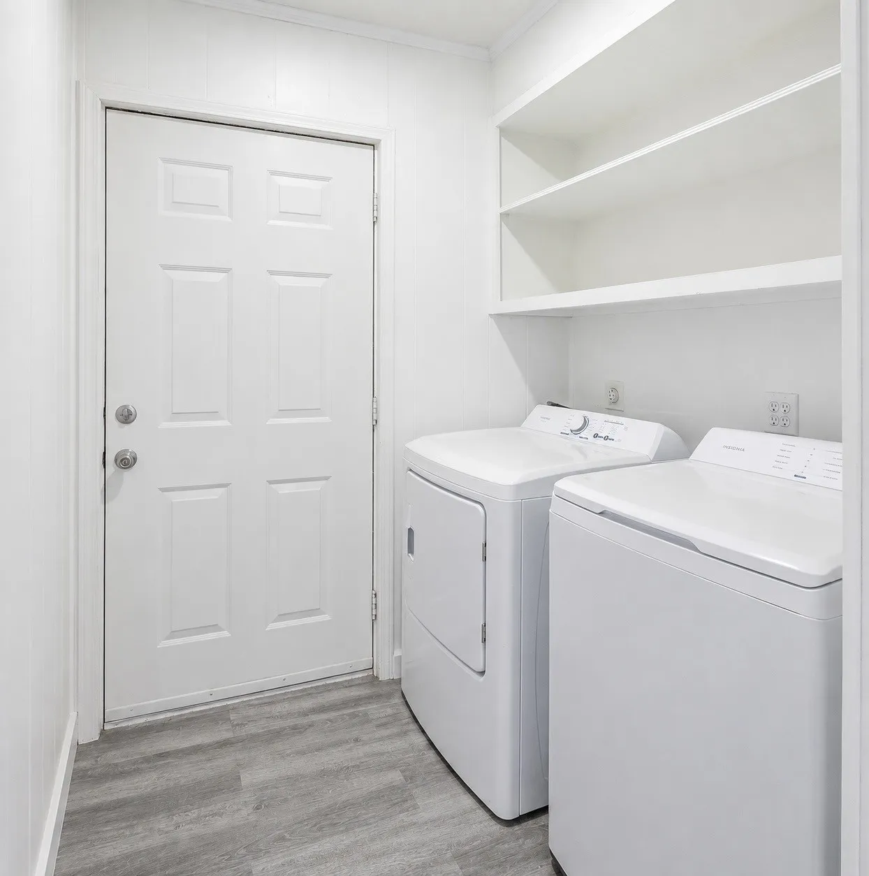 Laundry area featuring built-in shelving and wood-finish flooring