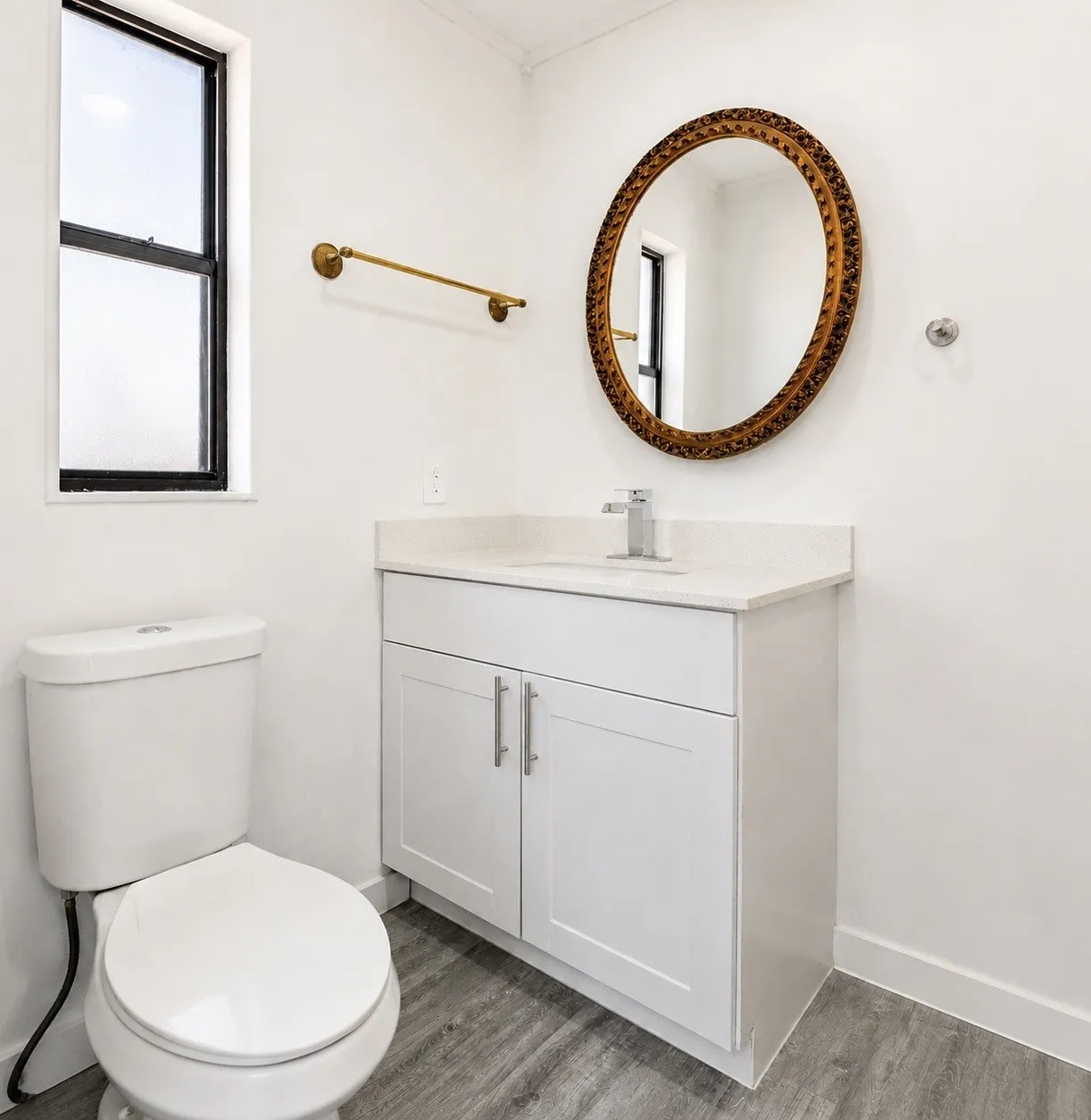 White vanity with Shaker-style doors, light-toned countertop, and chrome faucet