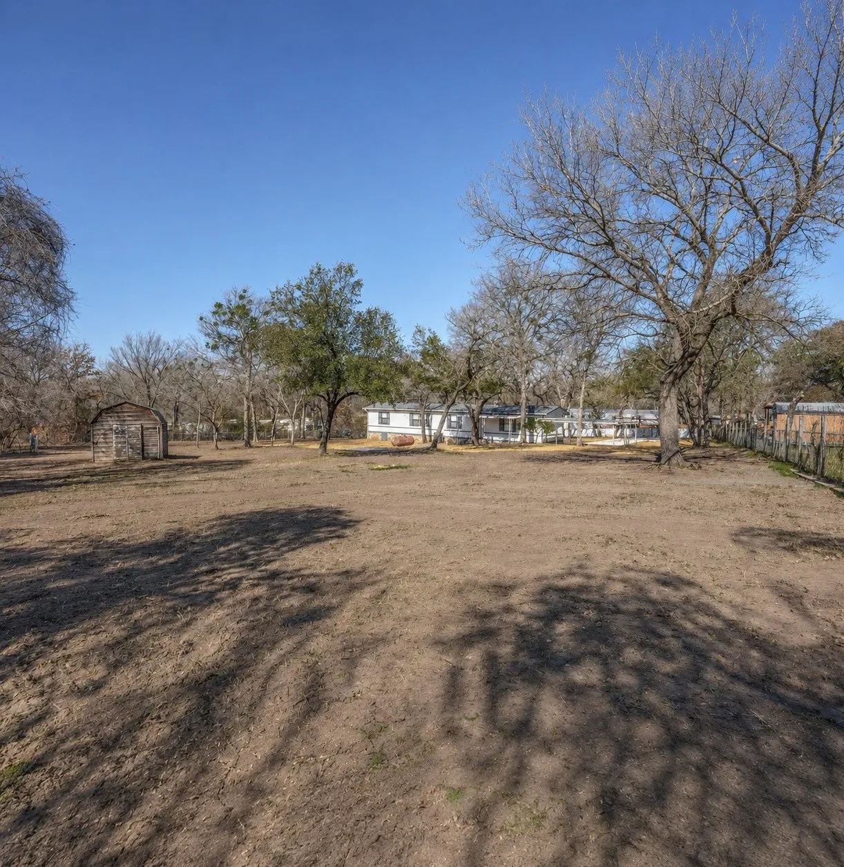 Expansive lot with mature trees and a rustic wood outbuilding