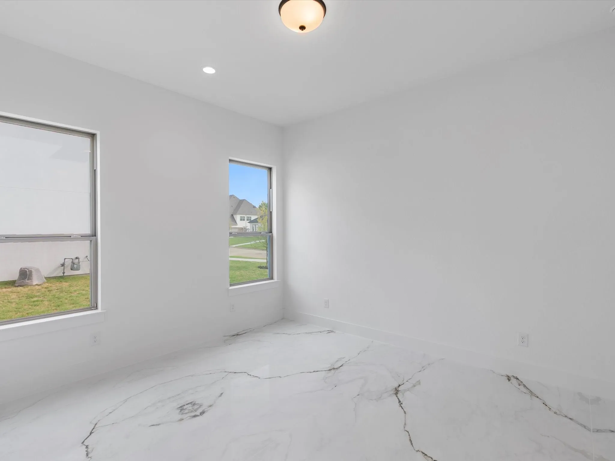 White walls with recessed lighting, a flush mount ceiling fixture, and two windows