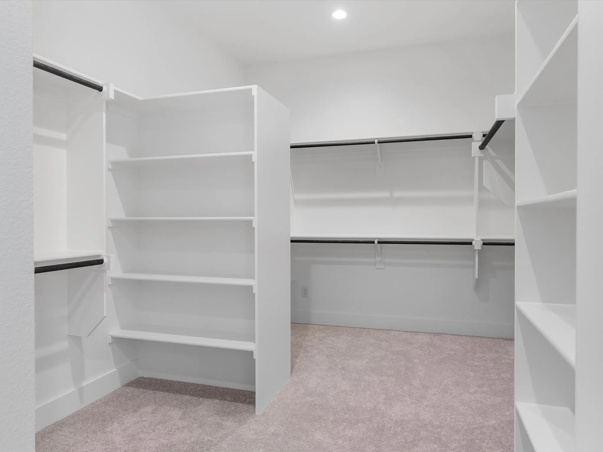 Custom closet system with multiple shelving units and ample hanging rods