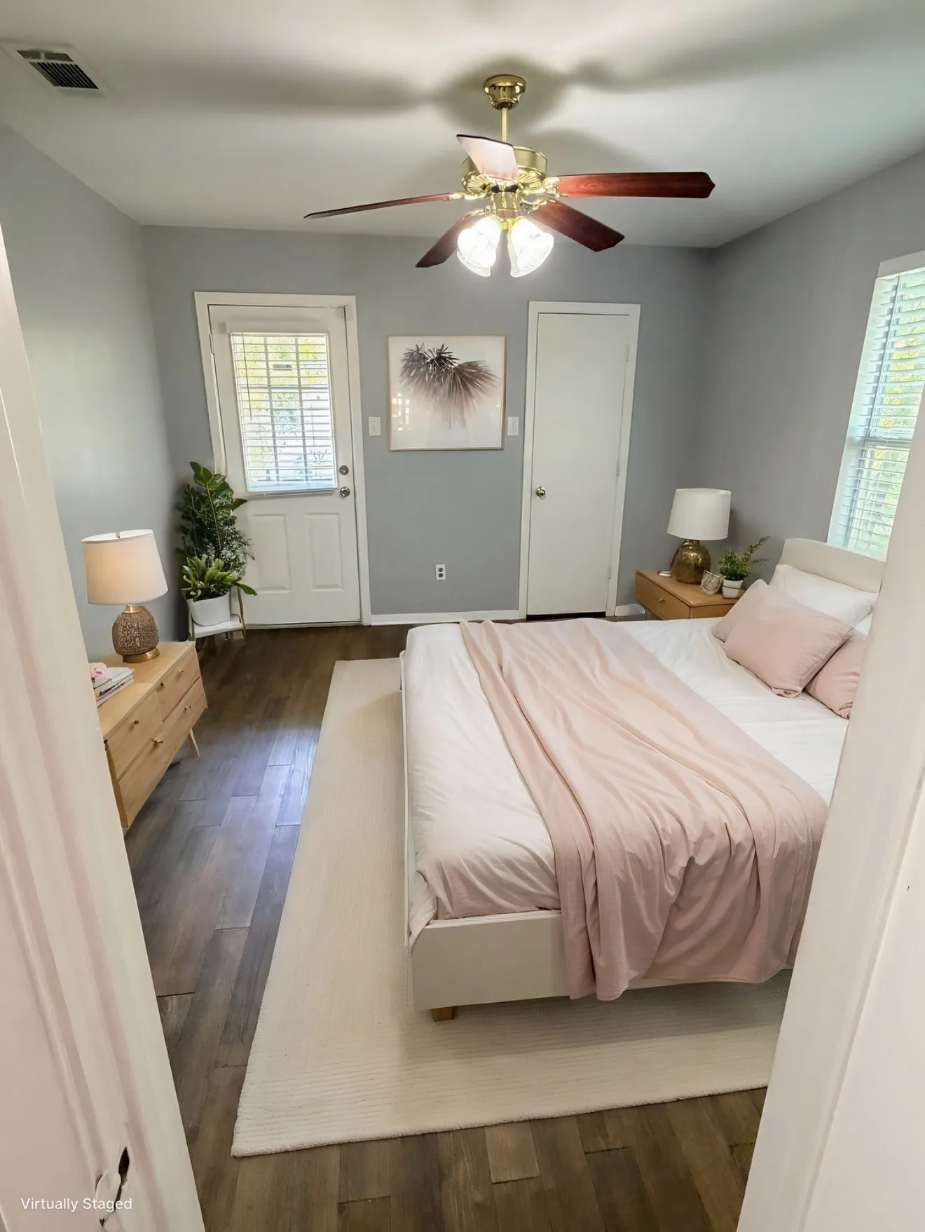 Wood-finish flooring, ceiling fan with integrated lighting, a white door with louvered blinds, and a solid white interior door