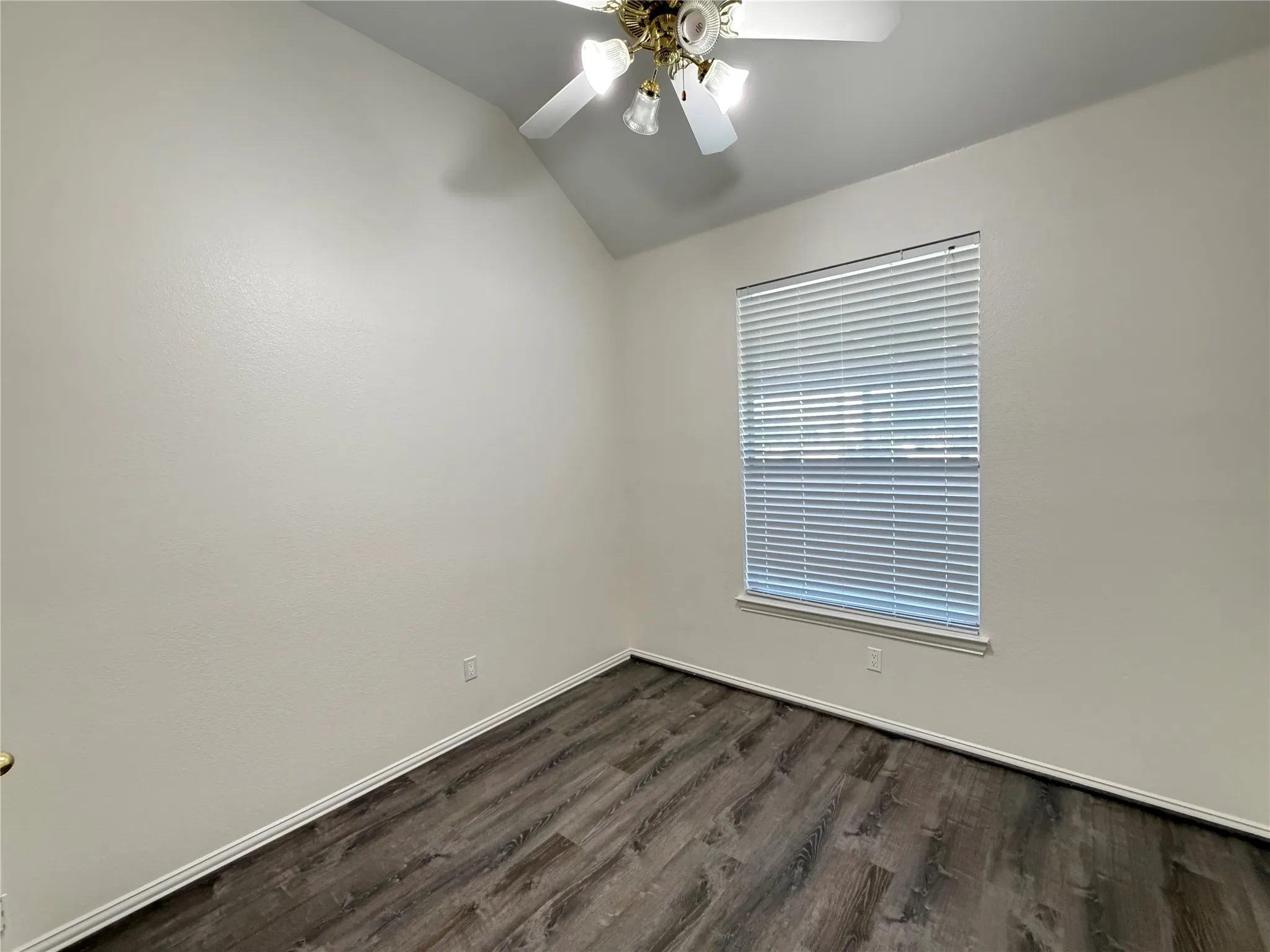Room featuring wood-finish flooring, a window with horizontal blinds, and a ceiling fan with integrated lighting