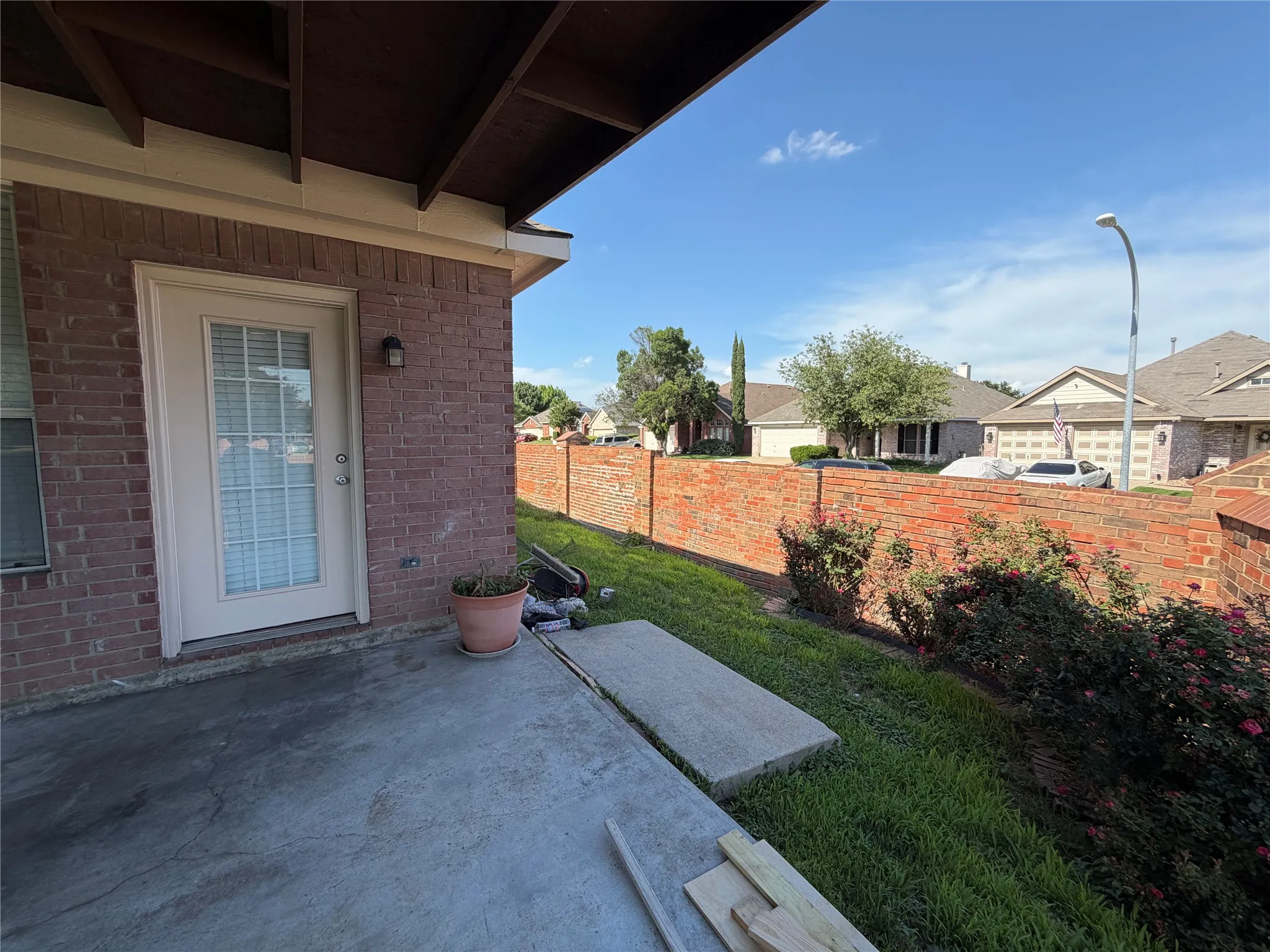Private outdoor patio featuring a concrete slab and brick exterior