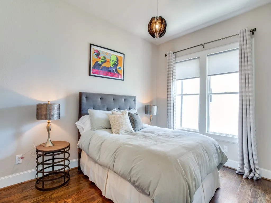 Hardwood-finish flooring, recessed windows, an upholstered headboard, and a contemporary ceiling fixture