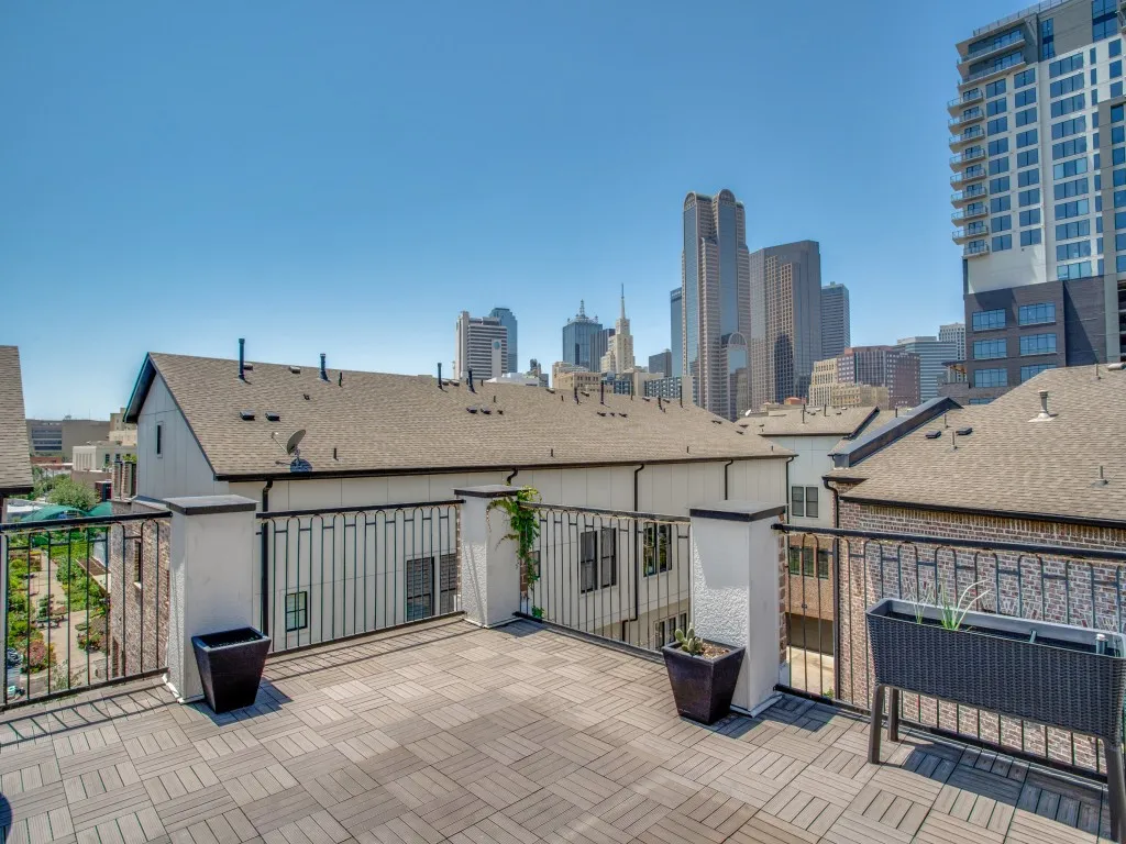 Rooftop terrace featuring modular pavers and a wrought iron railing