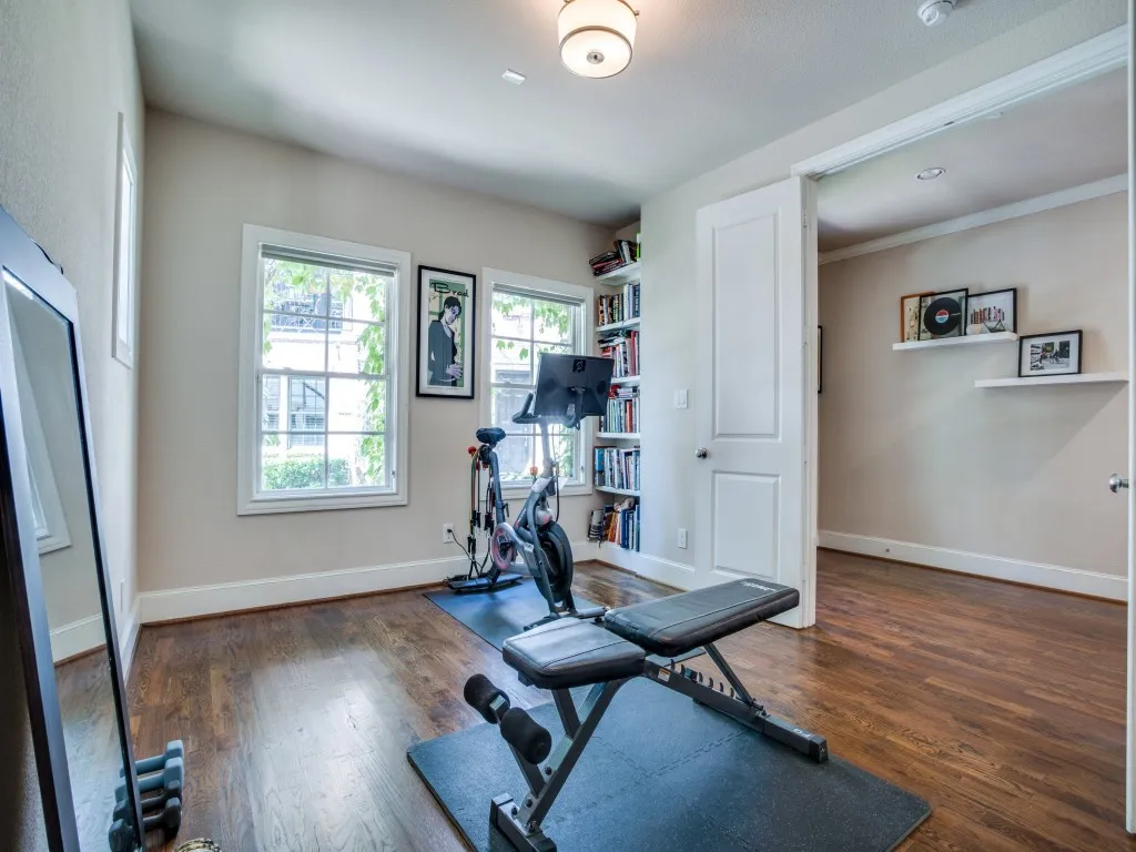 Hardwood flooring, recessed lighting, built-in shelving, white trim, and a white interior door