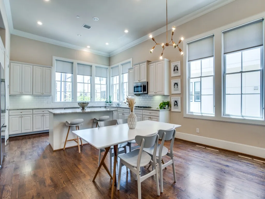 Kitchen featuring wood-finish flooring, white cabinetry, a central island with seating, a subway tile backsplash, and recessed lighting