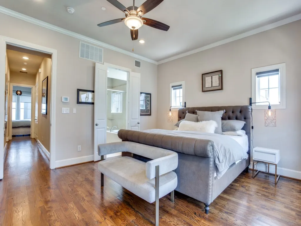 Hardwood-finish flooring, crown molding, ceiling fan with integrated lighting, dual transom windows, and white trim throughout