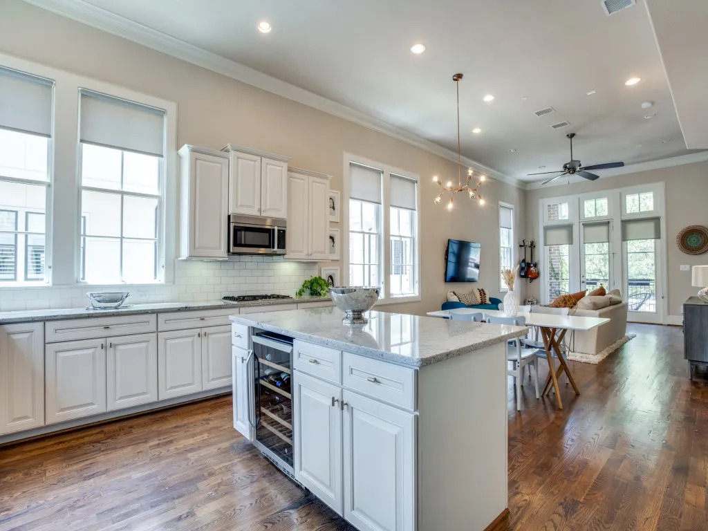 Gourmet kitchen featuring white cabinetry, subway tile backsplash, and a large island with built-in wine refrigeration