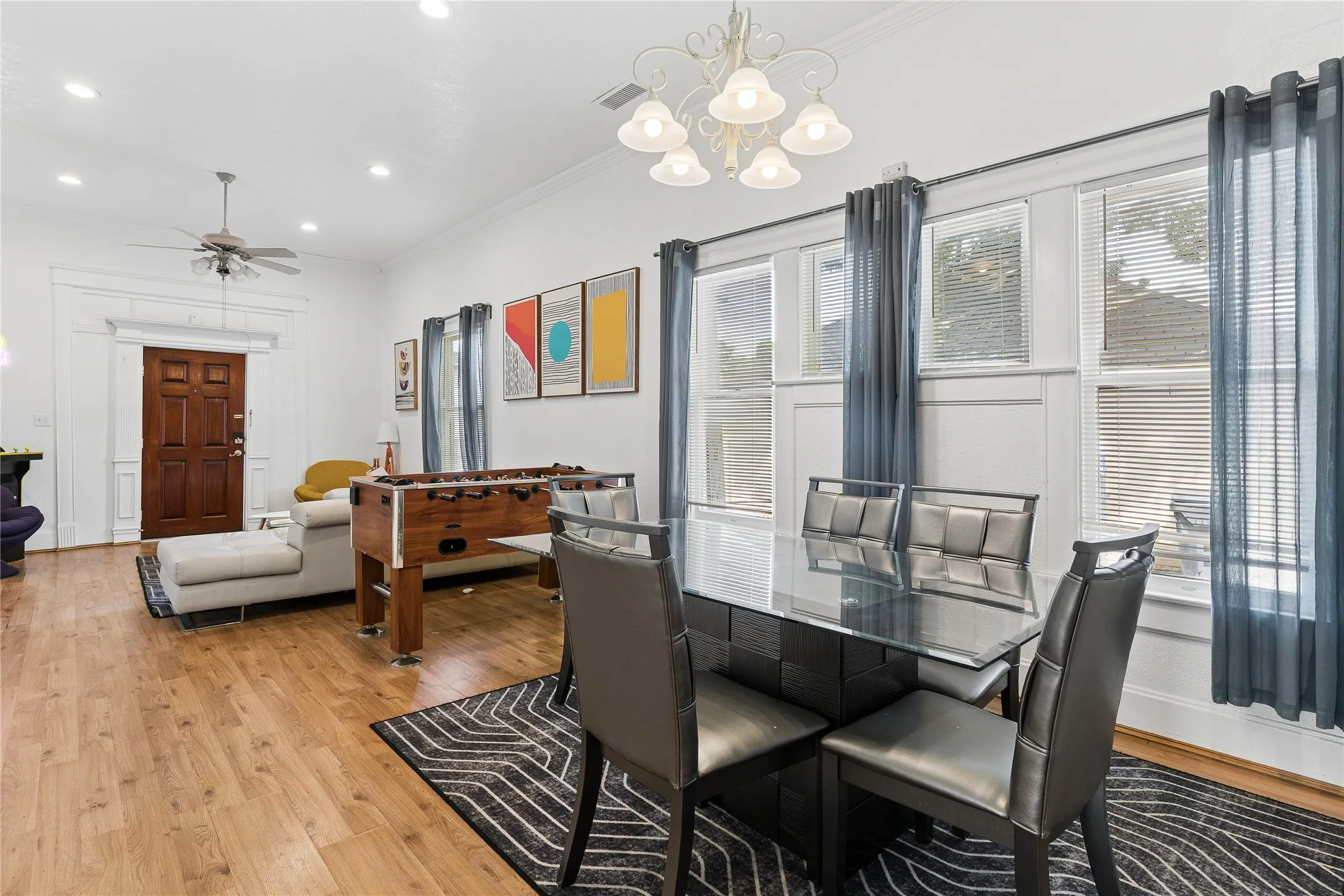 Open-concept living area featuring wood-finish flooring, recessed lighting, and a decorative ceiling fan