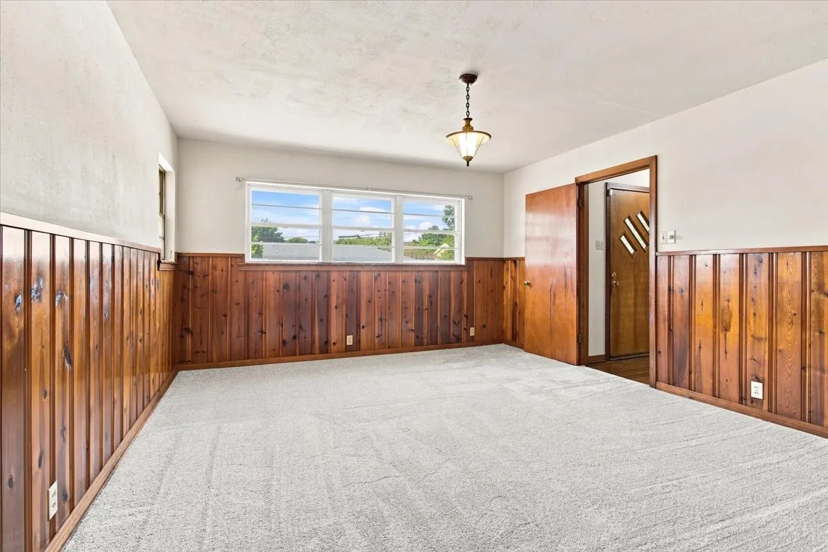 Flex space with upgraded carpet and pad, fresh paint, wood paneling, and natural light