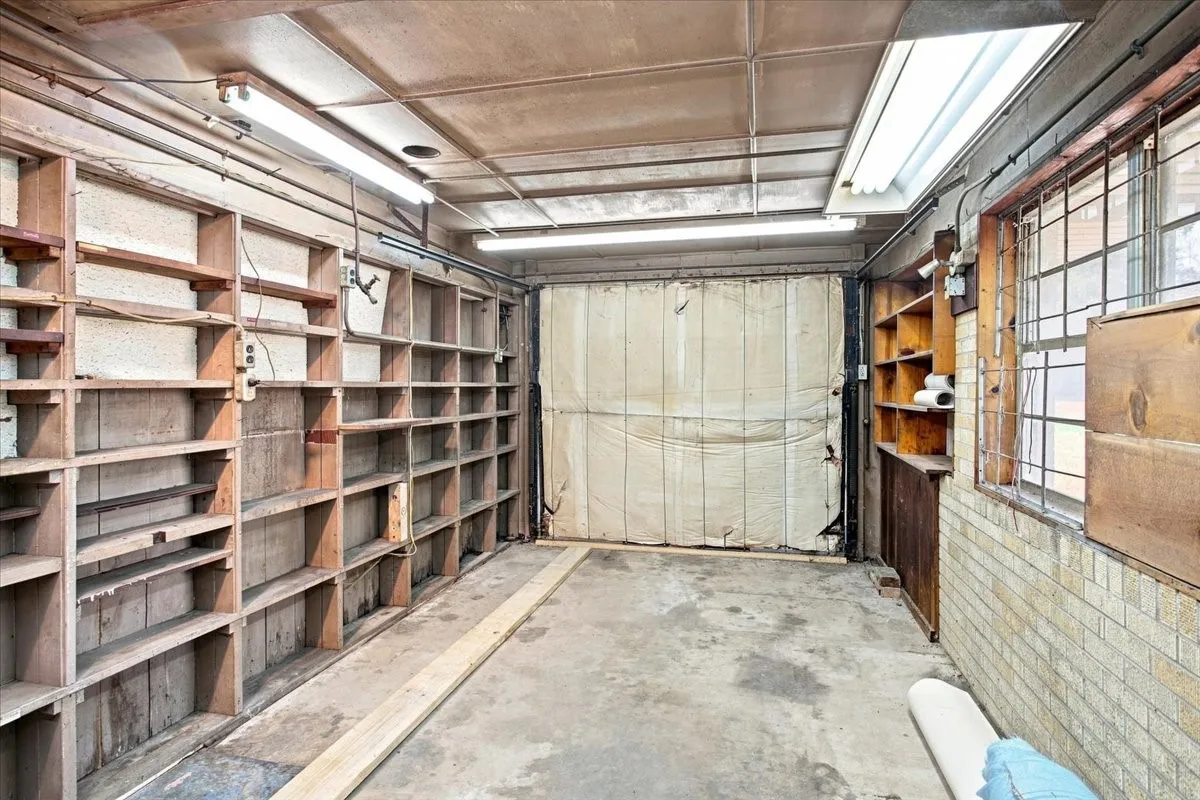 Garage was previously used as a shop. It has extensive built-in shelving, concrete flooring, and overhead  lighting. Ask about the built-in compressor that comes with the house!