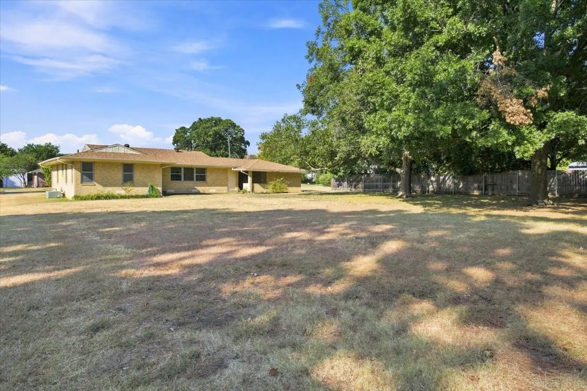 Expansive backyard featuring a mature Pecan tree.