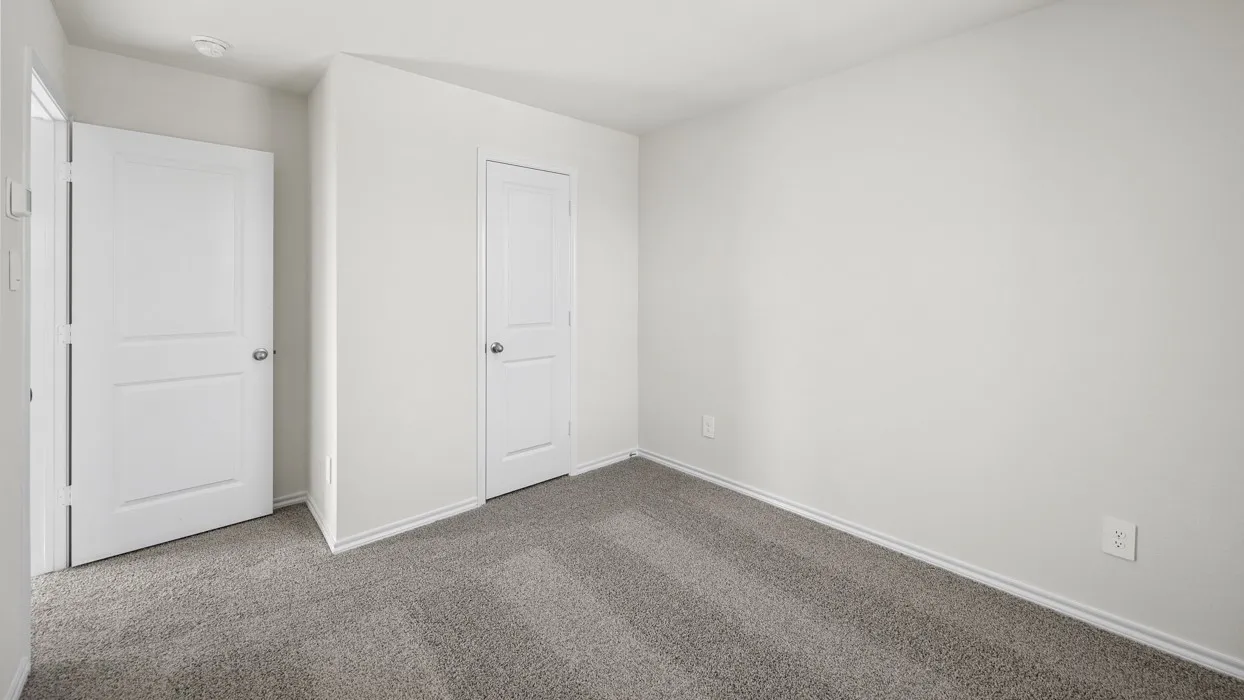 Neutral wall color, two-panel interior doors, and gray carpet