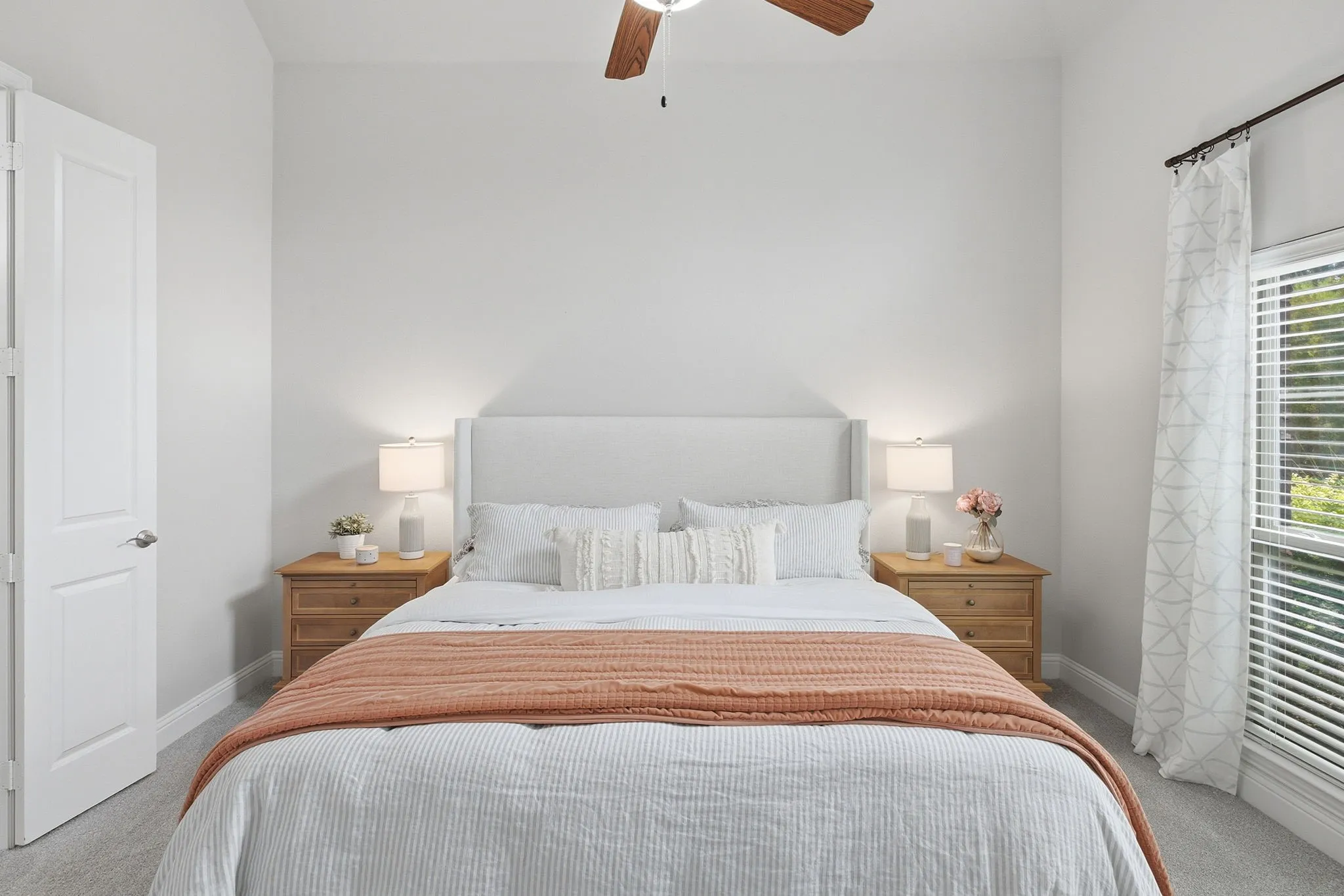 Recessed lighting, ceiling fan with wood-finish blades, white paneled door, window with blinds, and light gray carpet