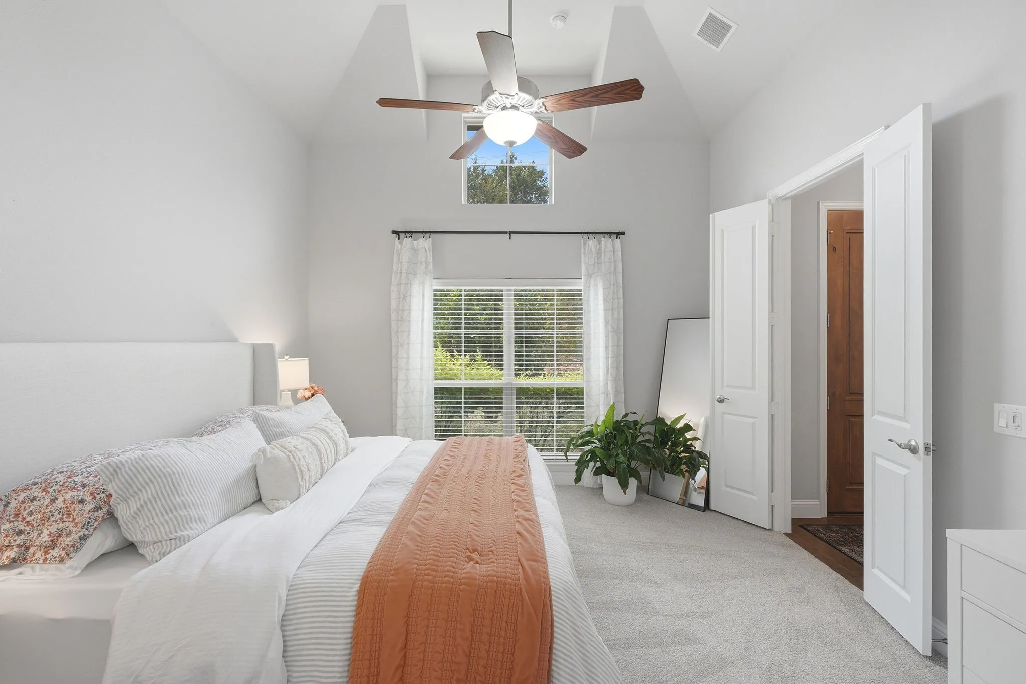 Vaulted ceilings, carpeted flooring, and a ceiling fan with light fixture