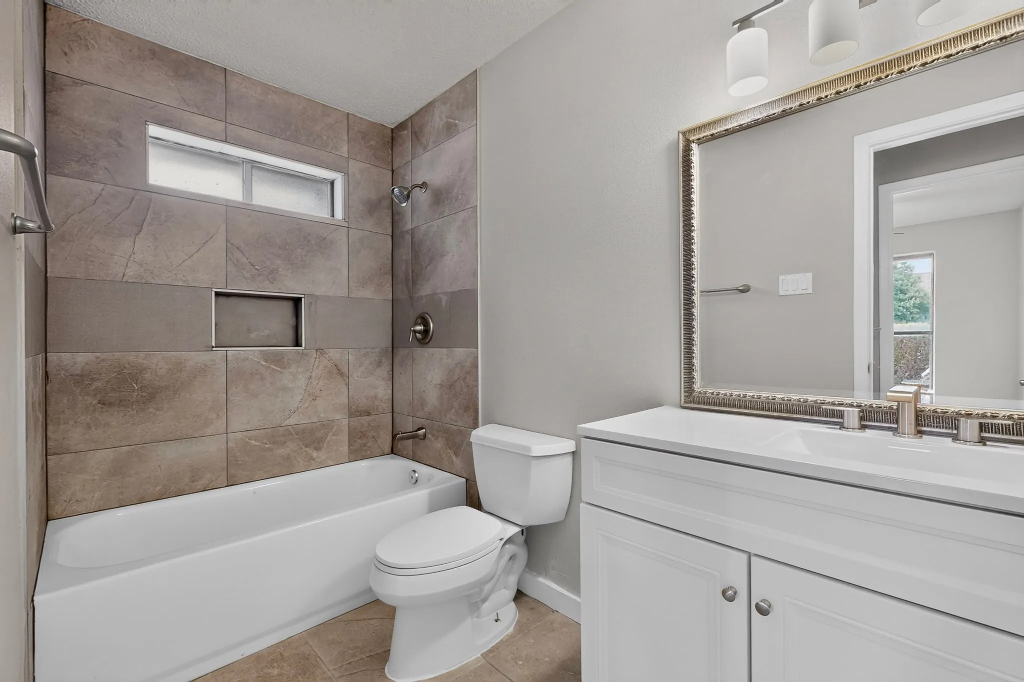 White vanity with dual sinks, framed mirror, and brushed nickel fixtures