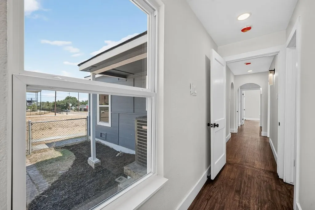 Hallway featuring wood-finish flooring, recessed lighting, and arched doorways