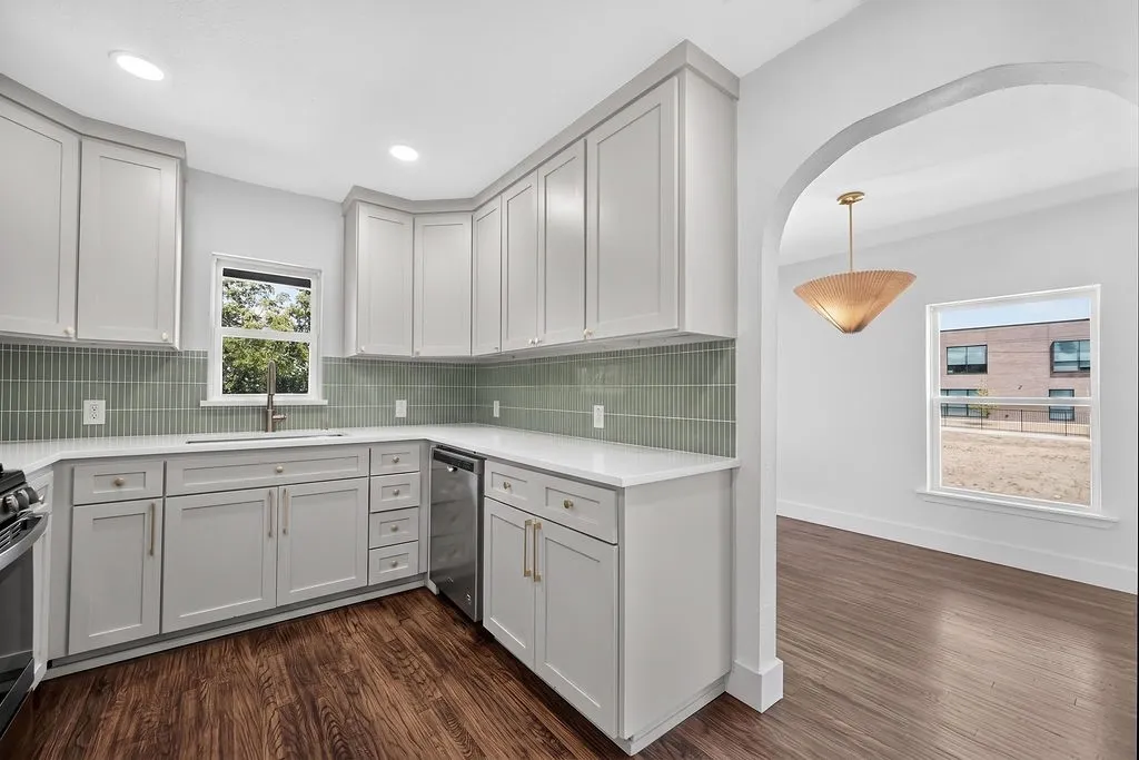 Kitchen featuring light gray cabinetry, white countertops, stainless steel sink with a gooseneck faucet, light green subway tile backsplash, and recessed lighting