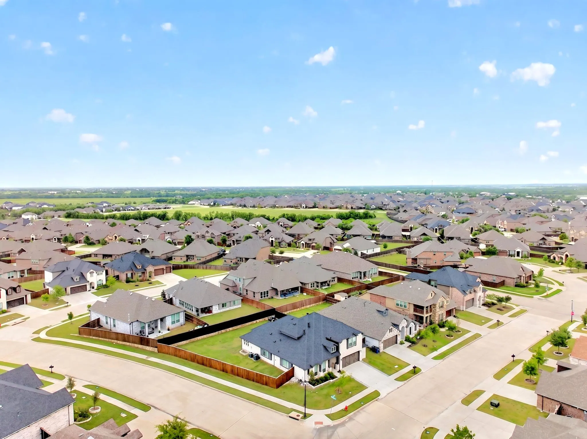 Expansive residential development with numerous single-family homes, each featuring individual fencing