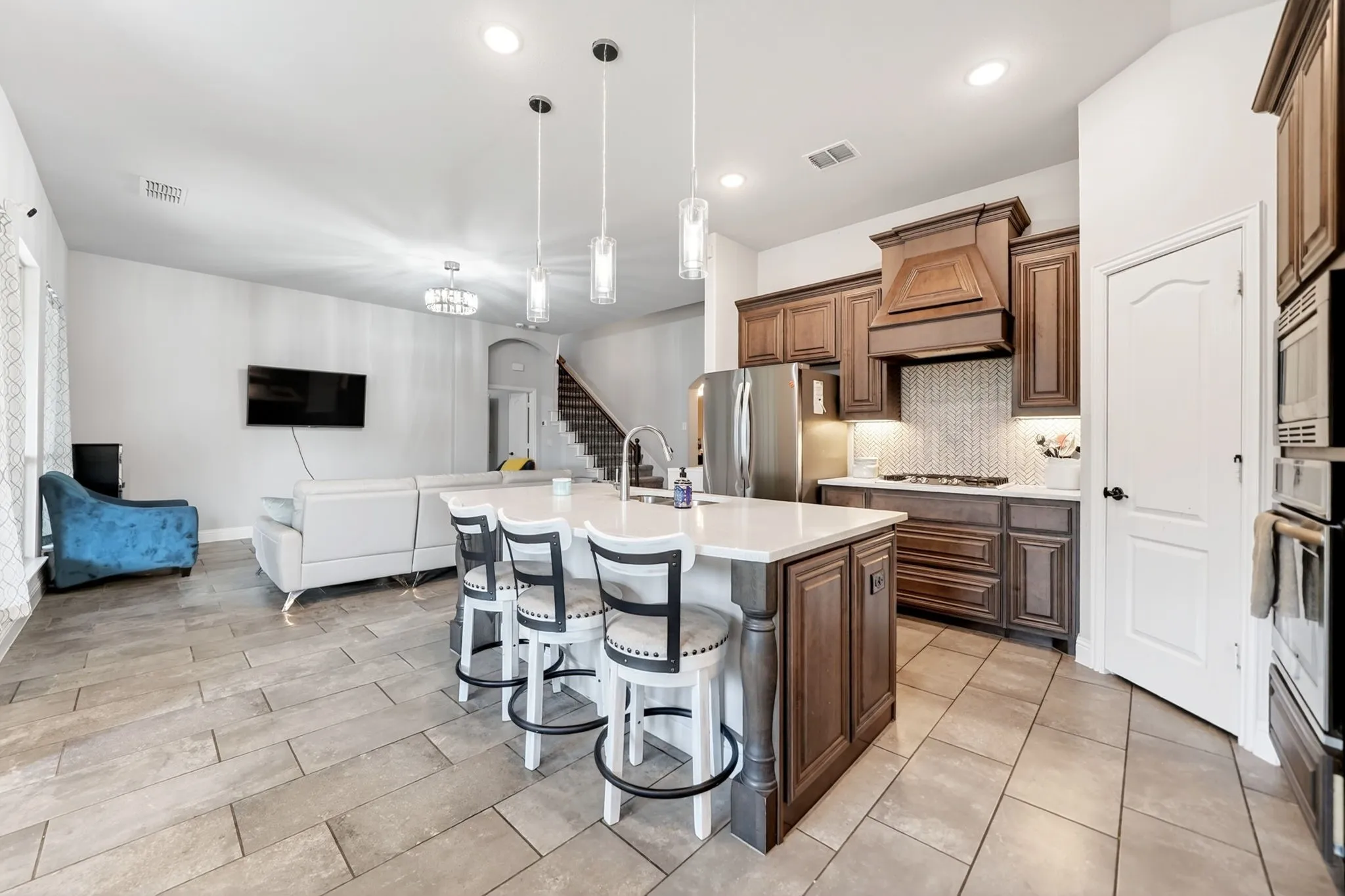 Gourmet kitchen with rich wood cabinetry, stainless steel appliances, and a tile backsplash
