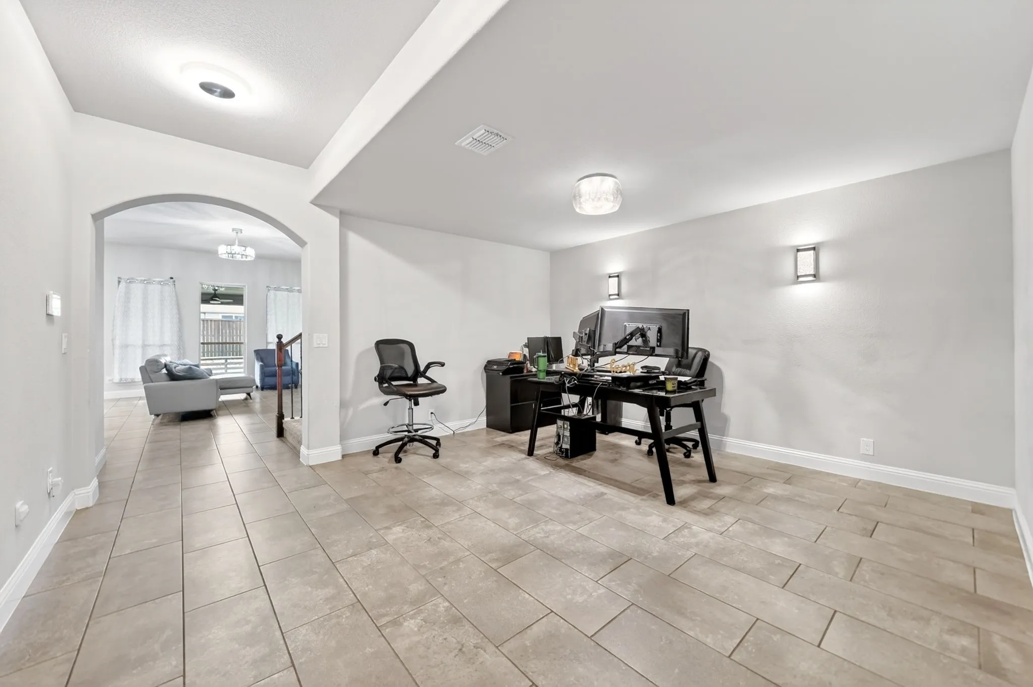 Tile flooring, recessed lighting, arched entryway, and wall-mounted sconces