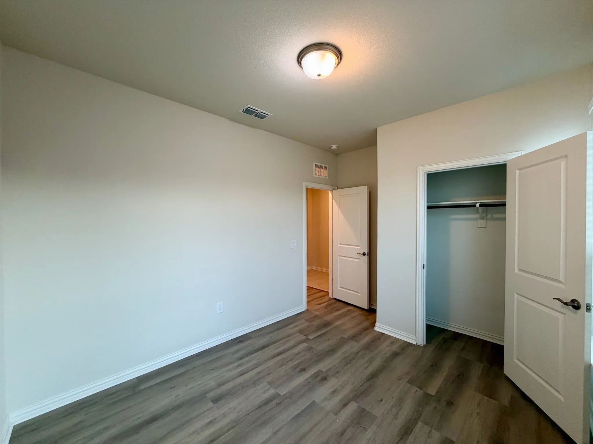 Wood-finish flooring, recessed lighting, and a built-in closet with hanging rod and shelf