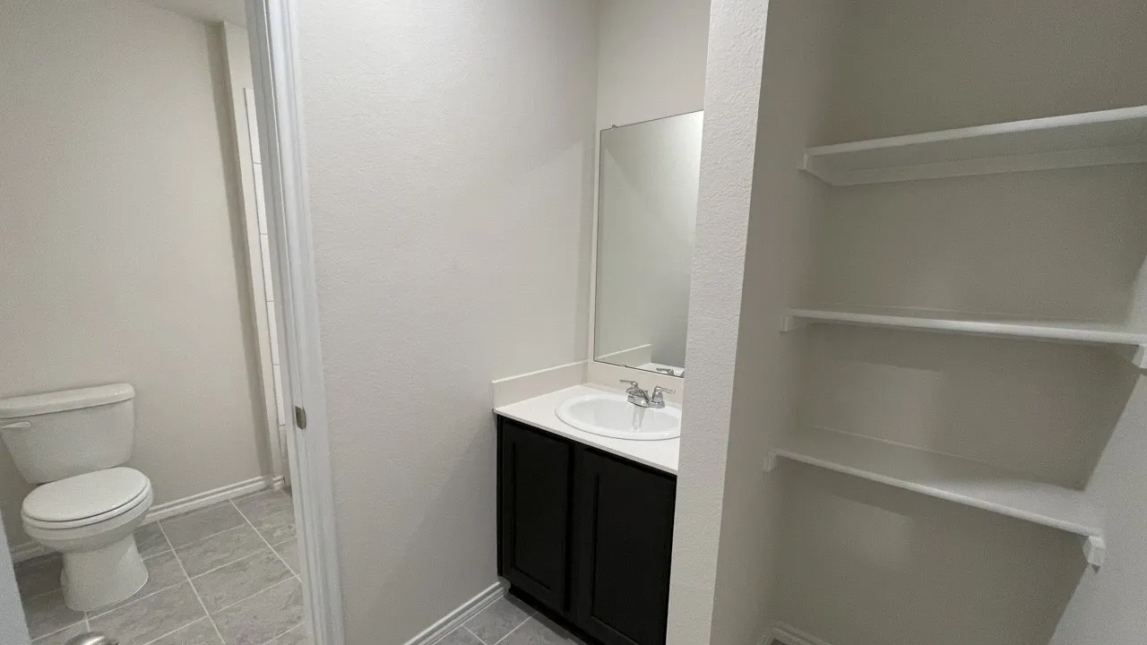Vanity with dark wood cabinetry, white countertop, and integrated sink