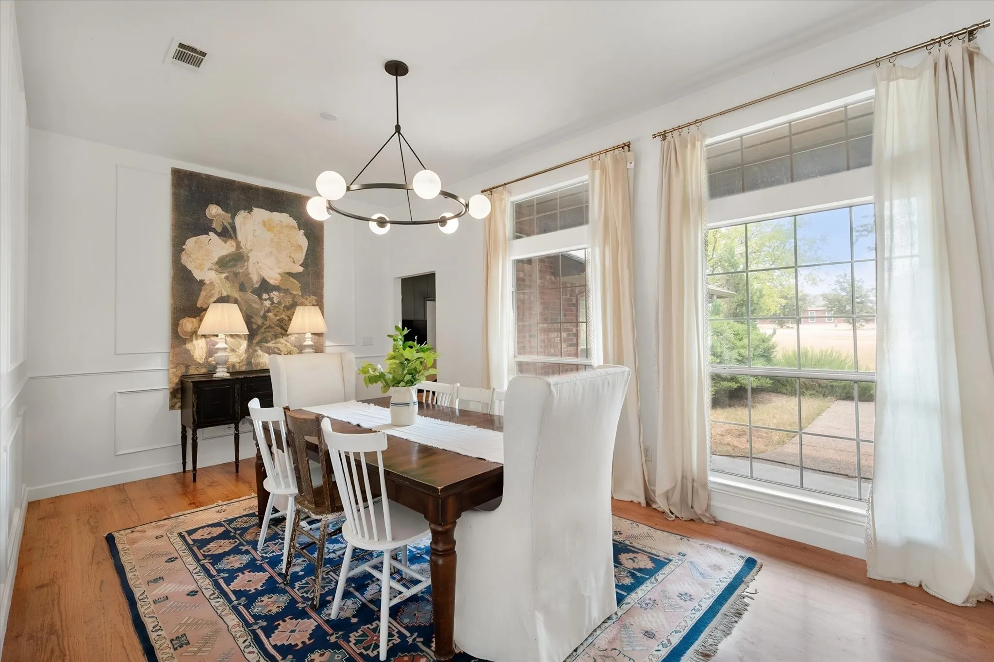 Formal dining area has modern lighting.