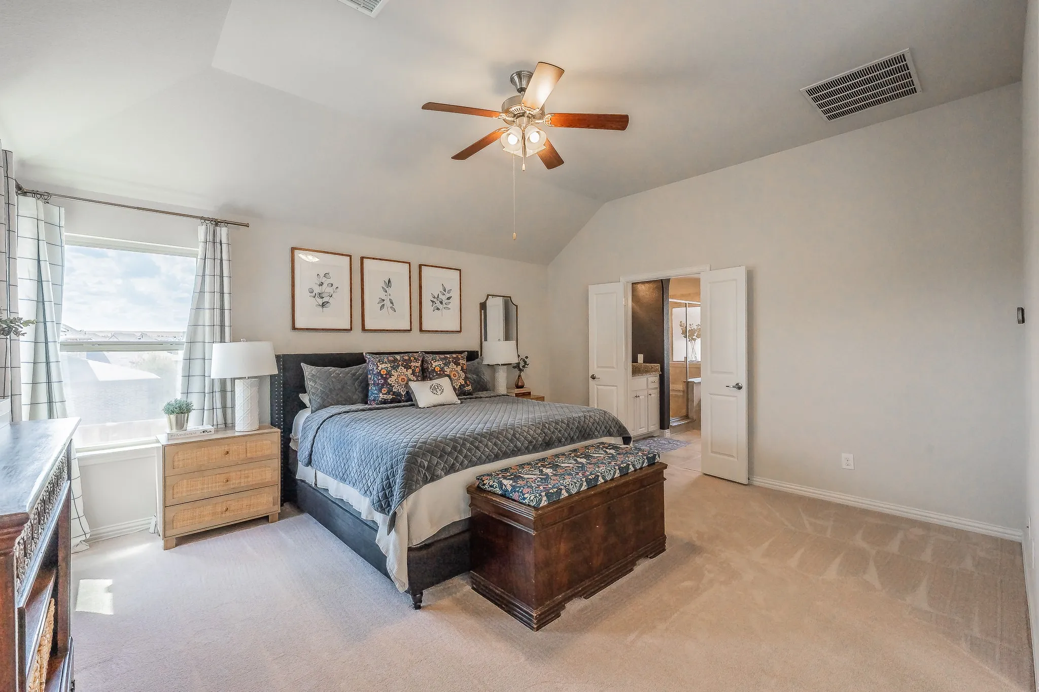 Vaulted ceiling with an attached ceiling fan, plush carpet, and a window with natural light