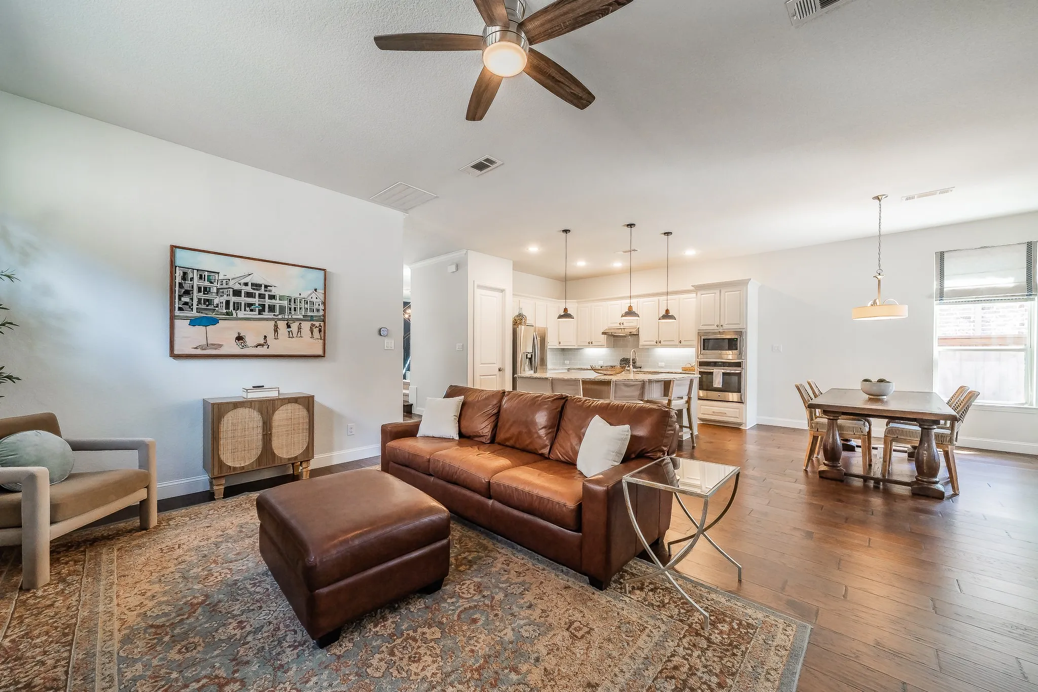 Open-concept living area featuring wood-finish flooring, recessed lighting, and a ceiling fan