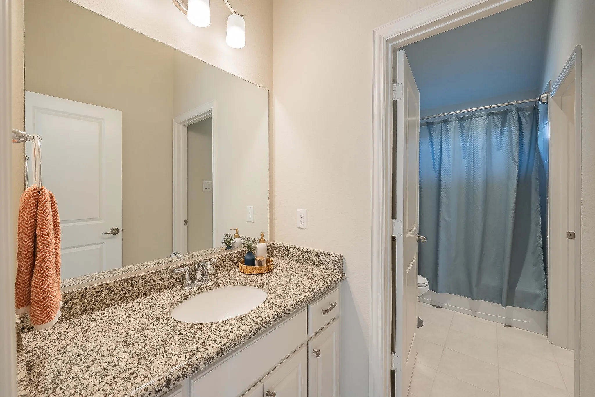 Vanity with stone countertop, undermount sink, and chrome faucet